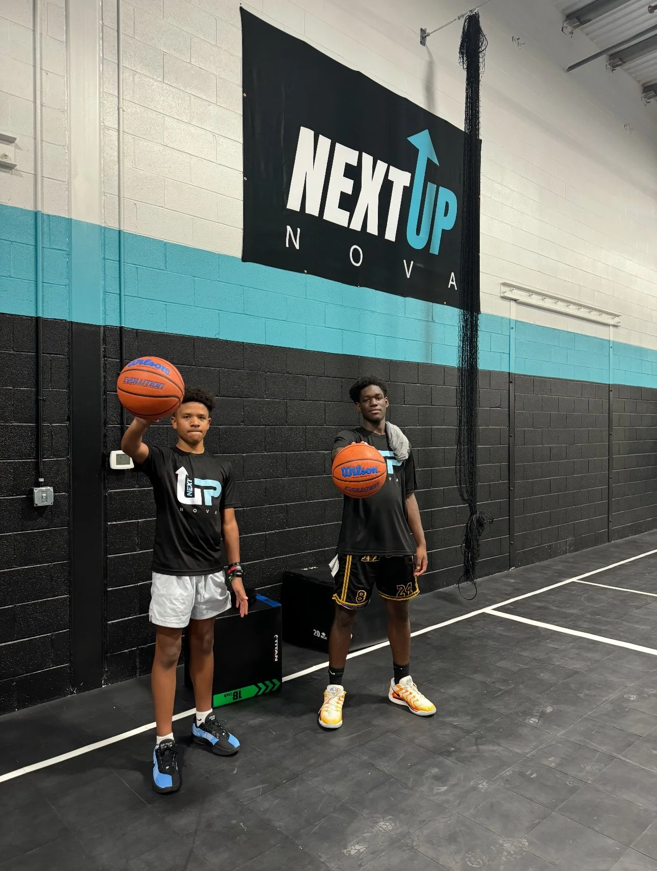2 young men holding up basketballs post-training session