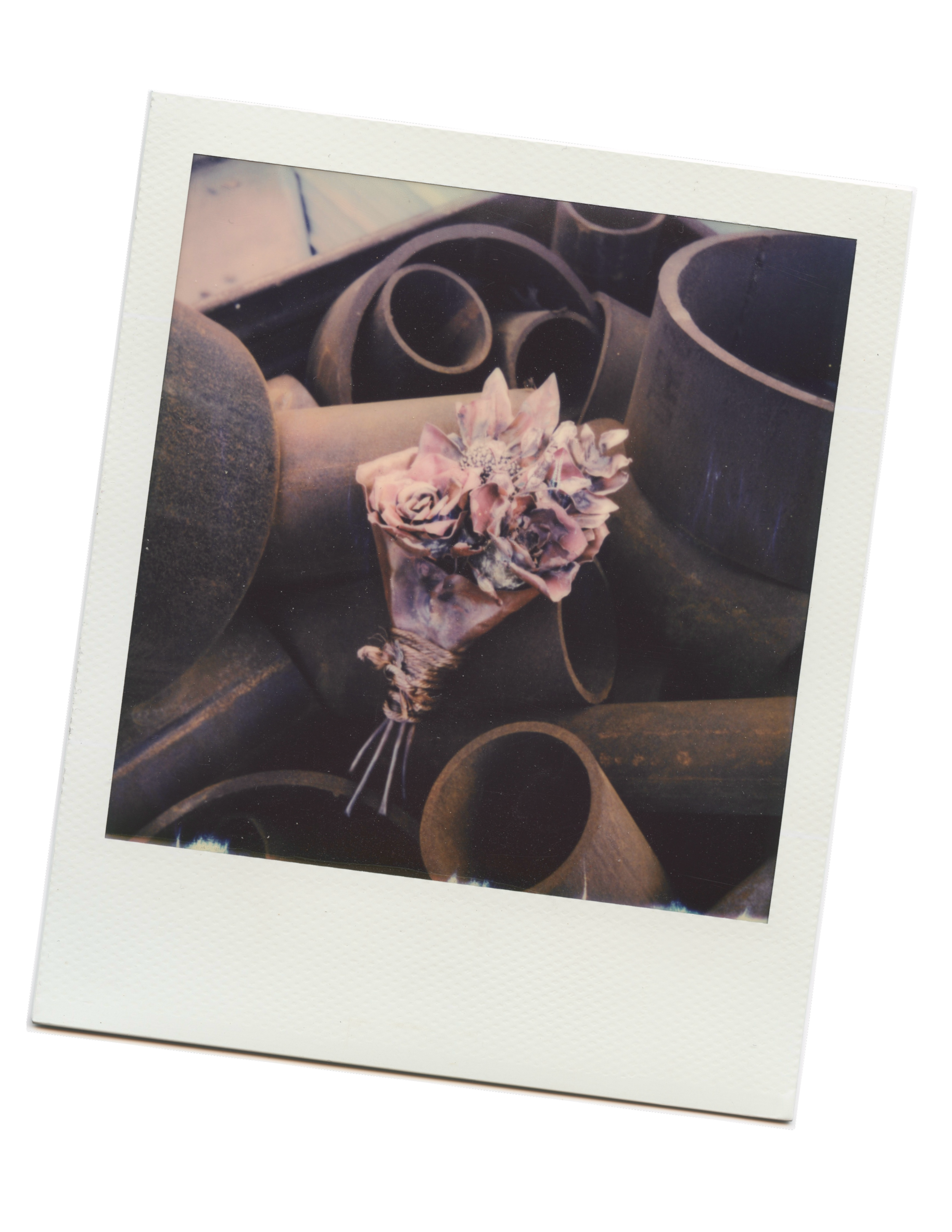 recycled-copper bouquet welded by Alex Matzke is photographed with a polaroid camera on top of a pile of steel pipes. Alex went to industrial welding school and learned alongside pipefitters.