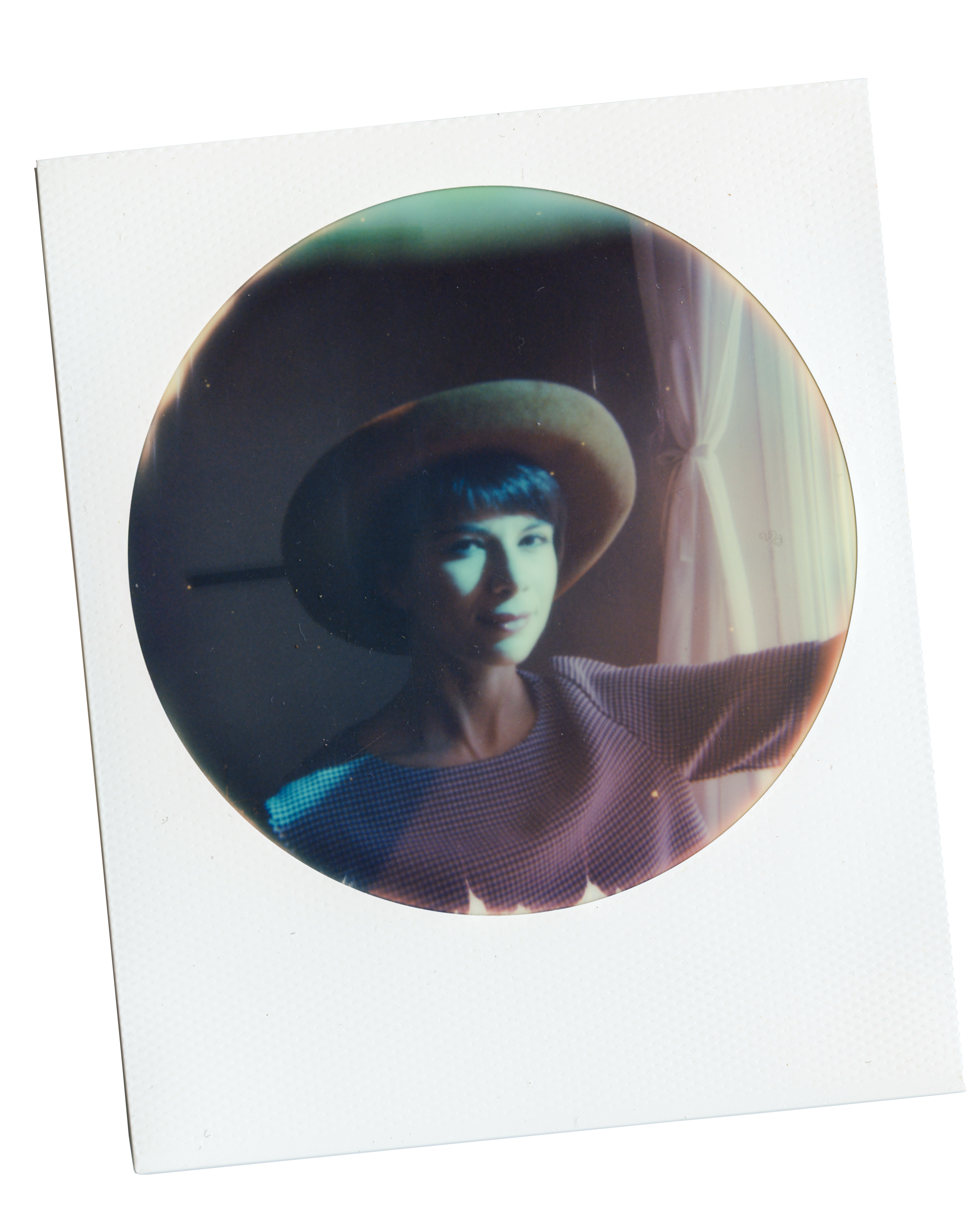 This circle frame polaroid of Angie, made at her home. Angie was entered into a contest to win polaroid film and Alex Matzke photographed her in front of a window, holding a blue filter to create the blue light on her face and shoulder.