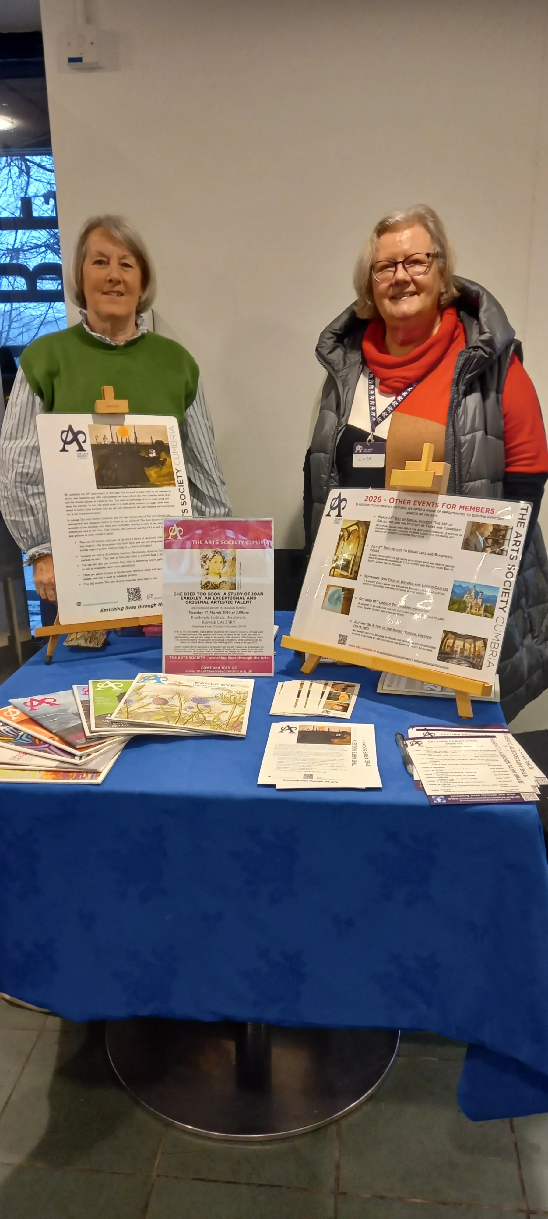 Linda Ivison, Chairman, and Fiona Campbell, Arts Society Cumbria welcoming visitors to Words by the Water