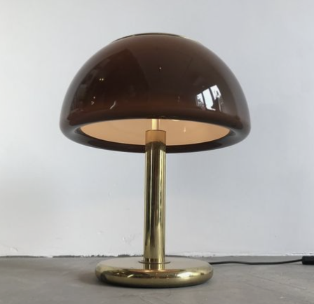 A modern table lamp with a gold base and stem, and a dark brown, semi-spherical lampshade.
