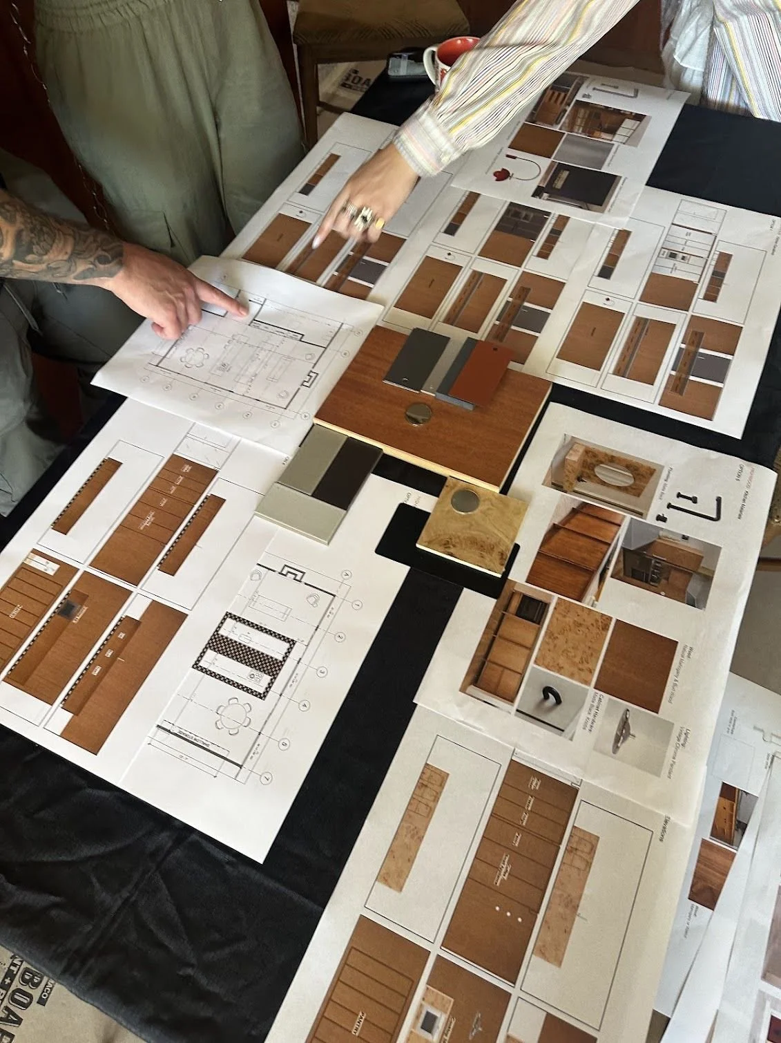 Group of five people standing and talking at a construction site with a partially built house behind them.