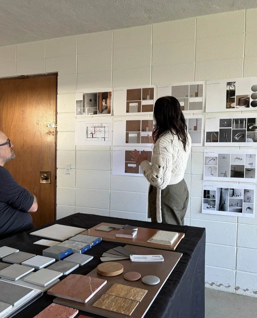 Modern kitchen with wooden cabinets, green marble countertops, and a built-in oven. Large window with a view of trees outside.
