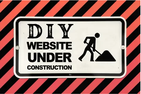 Sign reading 'DIY Website Under Construction' with a graphic of a person digging with a shovel, set against a red and black striped background.