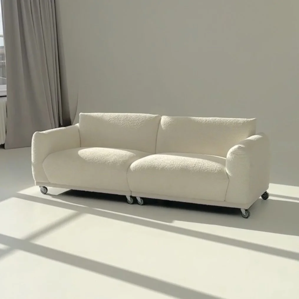 Beiges Sofa mit zwei Rückenkissen und breiten Armlehnen auf weißem Hintergrund.