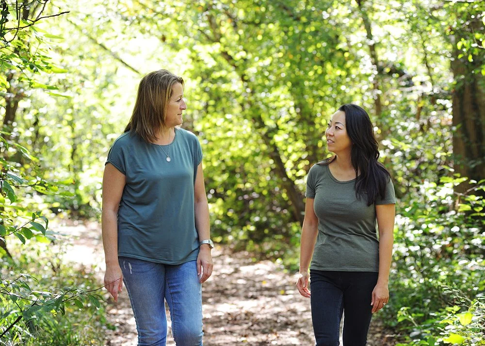 Zwei Frauen gehen in der Natur spazieren und unterhalten sich
