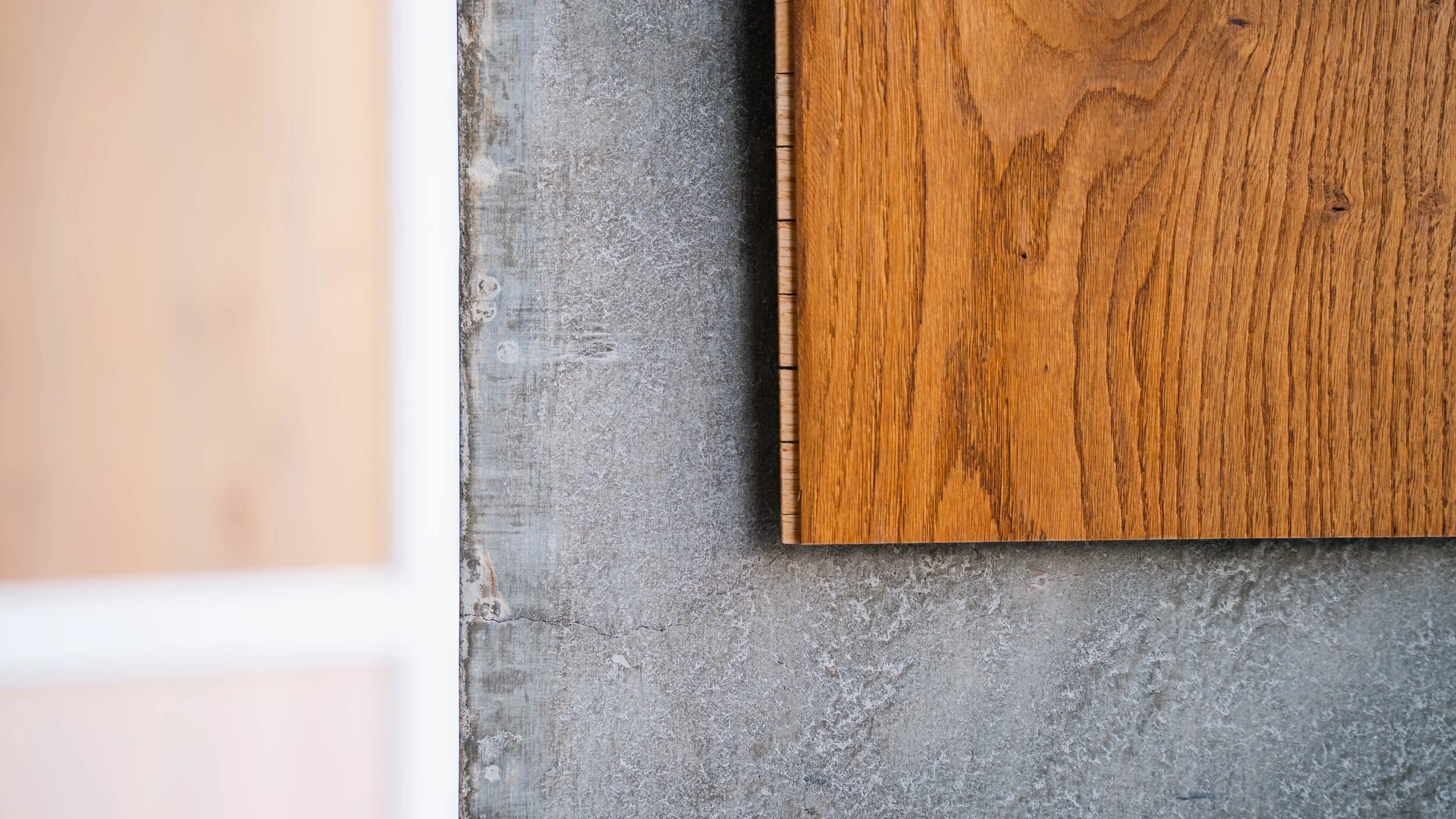 Close-up of a wooden tabletop corner on a concrete floor.