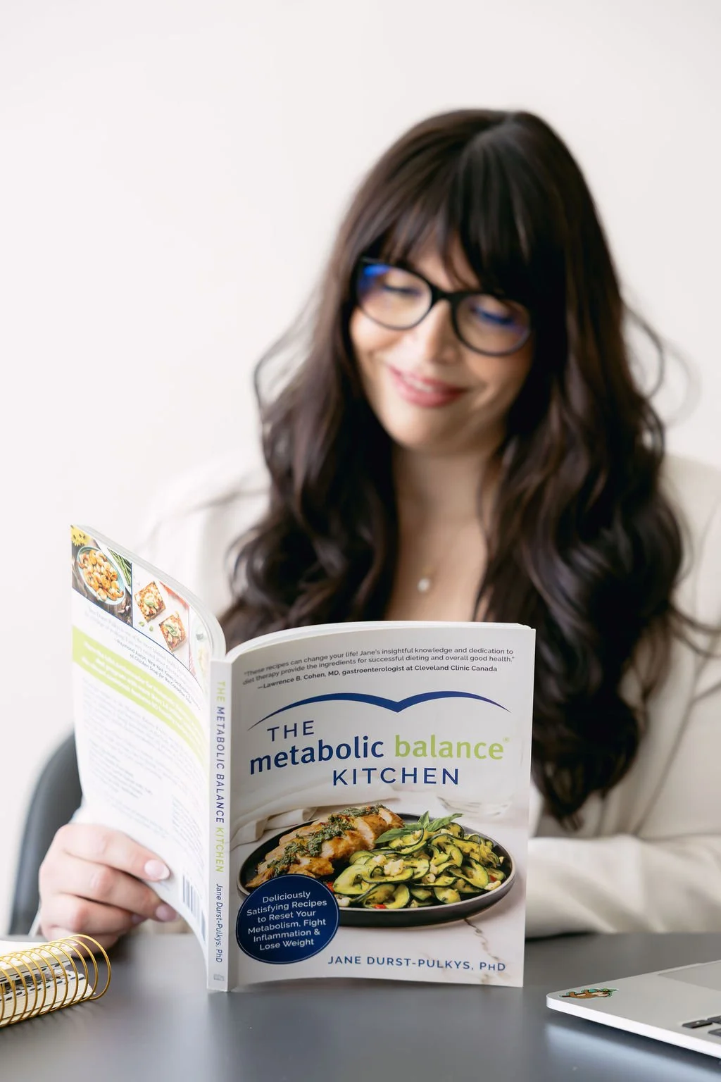 A picture of a lady reading The Metabolic Balance Kitchen cookbook.