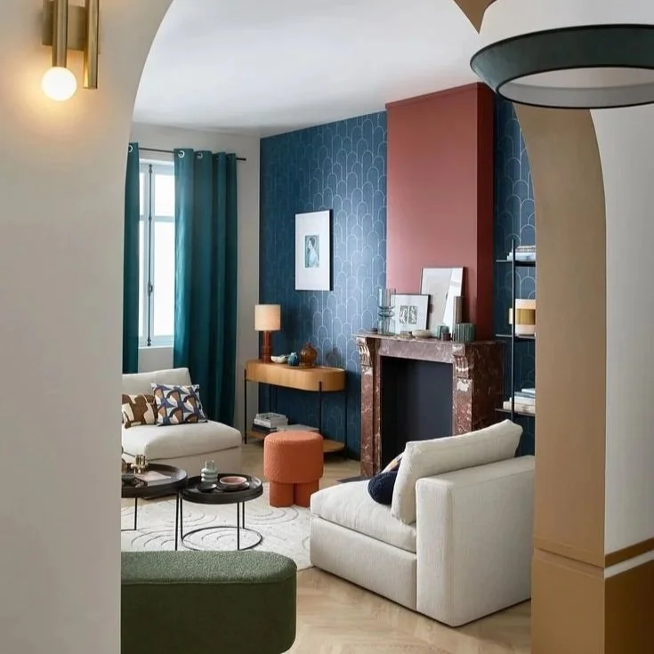 Vue depuis une couloir d'un salon avec un mur bleu foncé et des détails d'autres couleurs