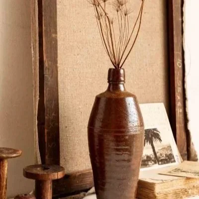 Vase en terre avec des matières lin, bois en second plan