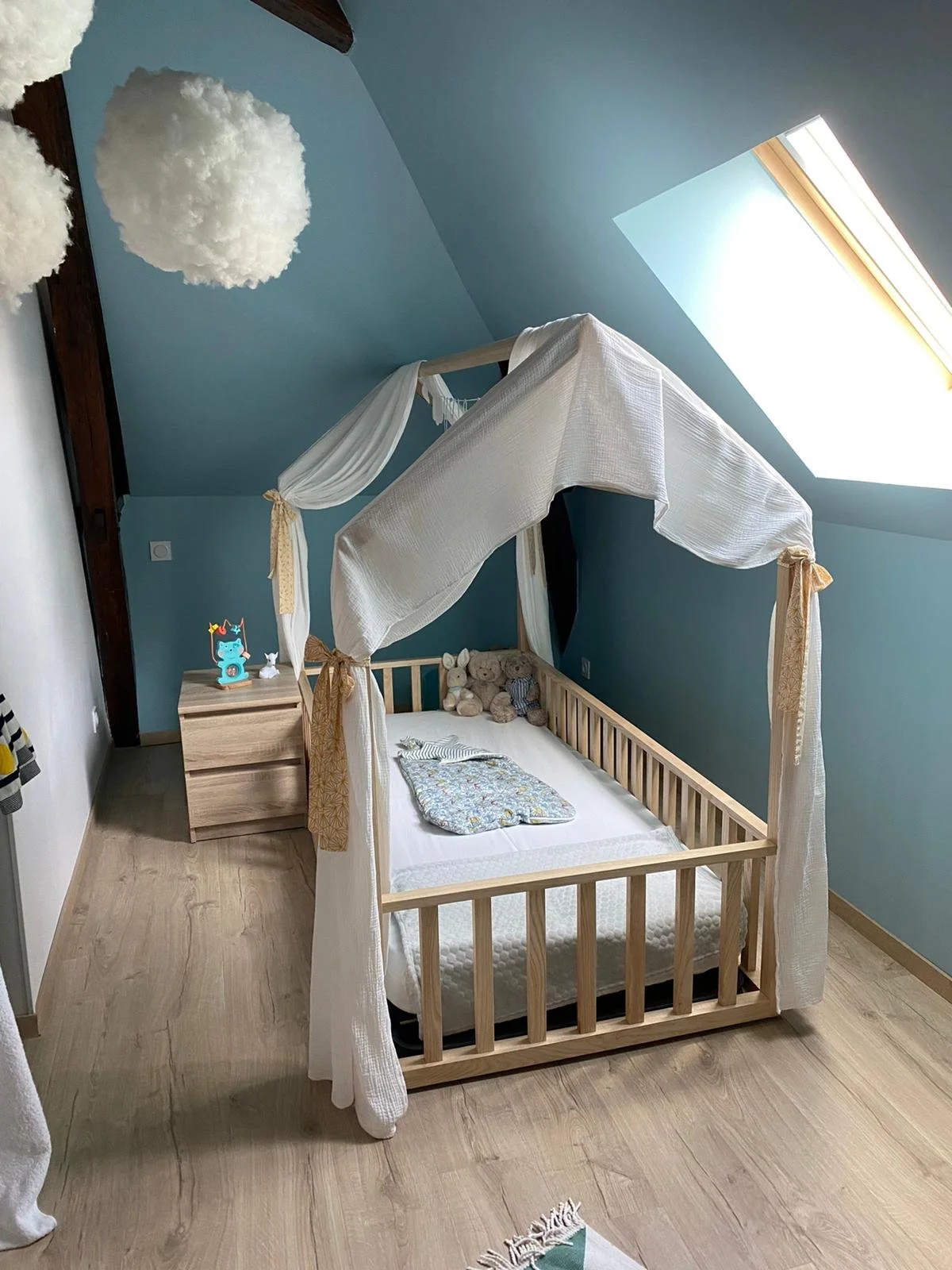 chambre bébé Montessori, mur bleu, tapis triangles bleus, lit cabane