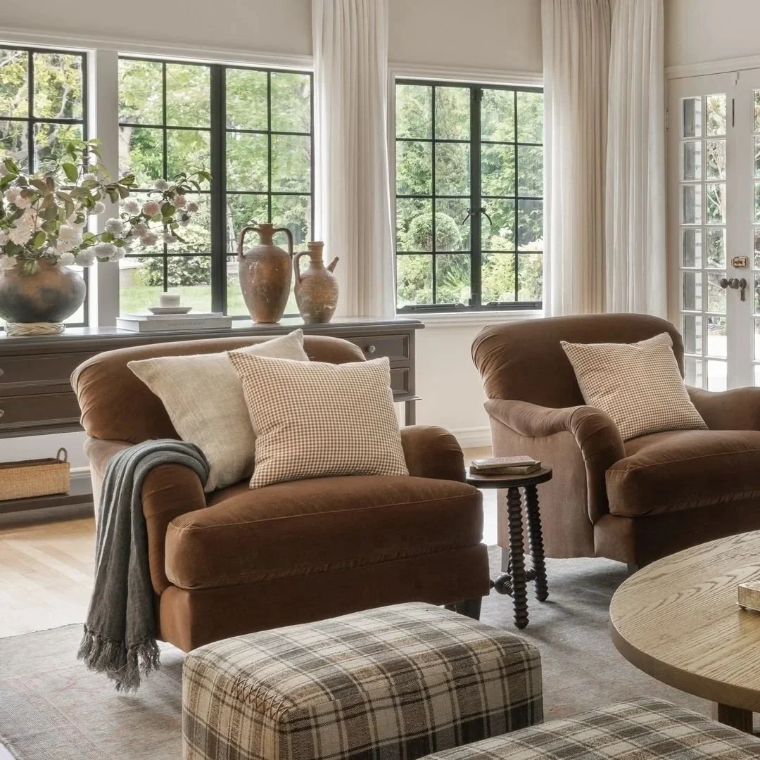 Salon avec deux fauteuils cosy aux tons bruns