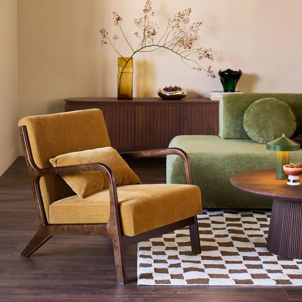 Siège jaune moutarde au premier plan, un canapé vert au second plan