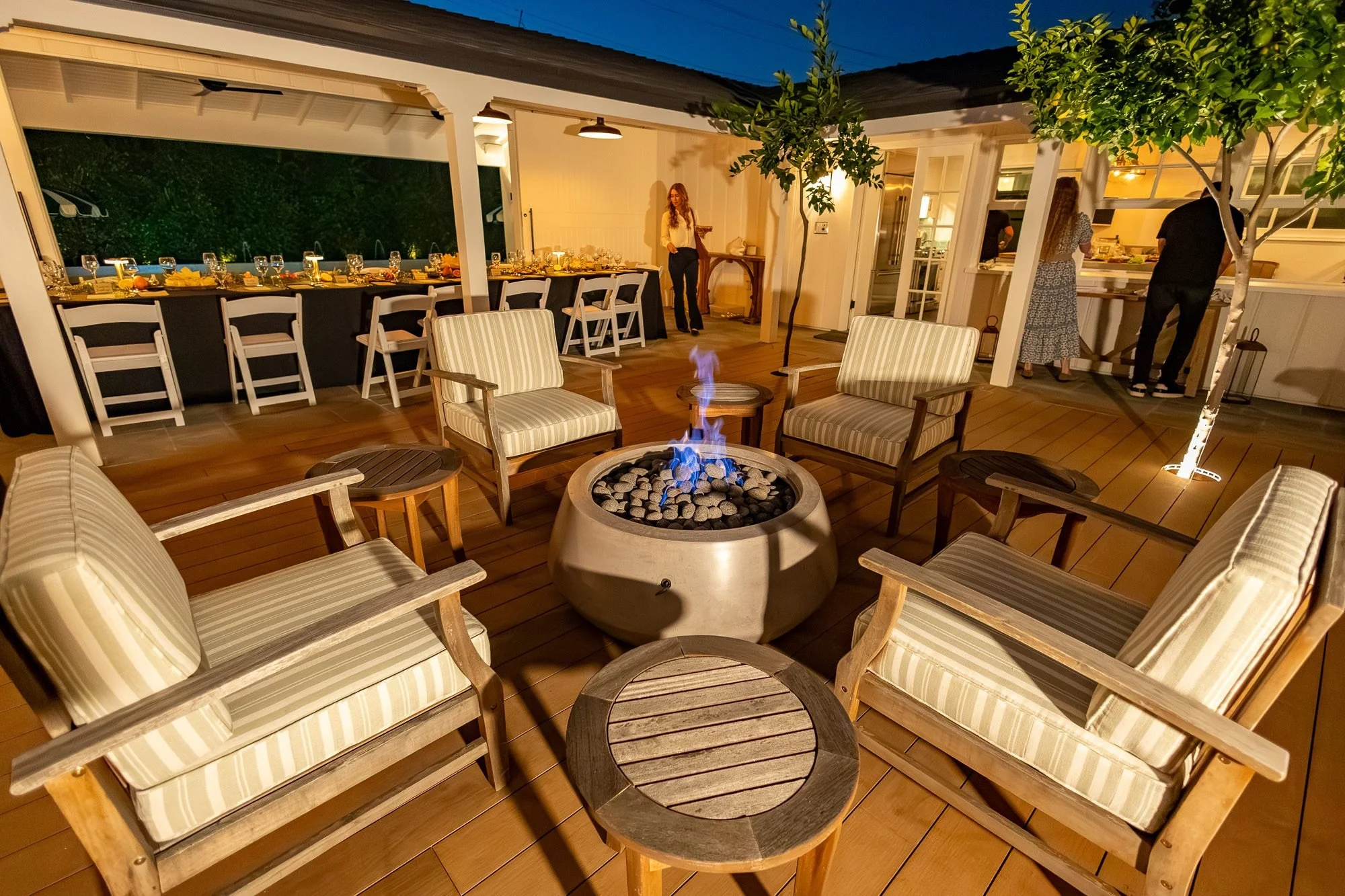 Outdoor lounge seating around a fire pit on the covered patio