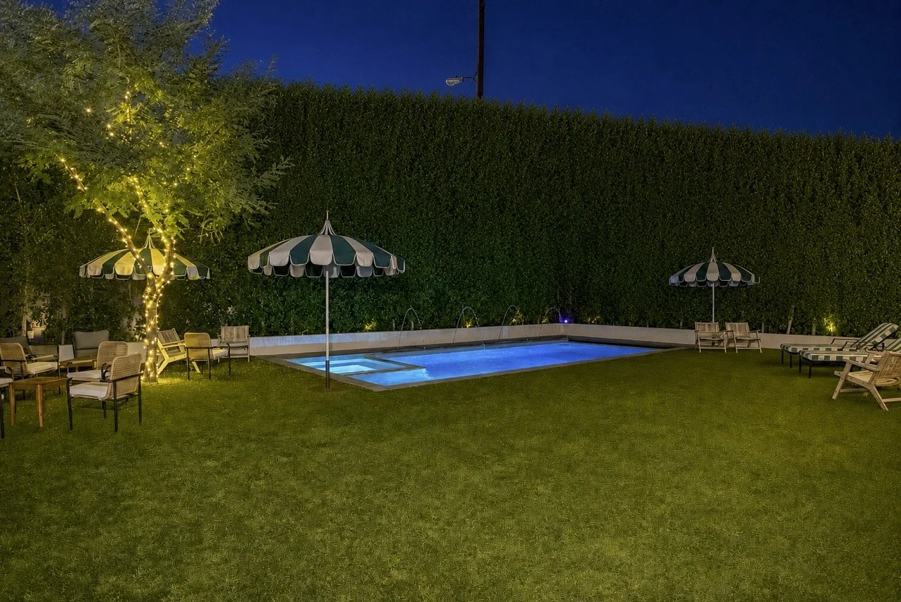 Poolside lounge area with striped umbrellas lit up at night