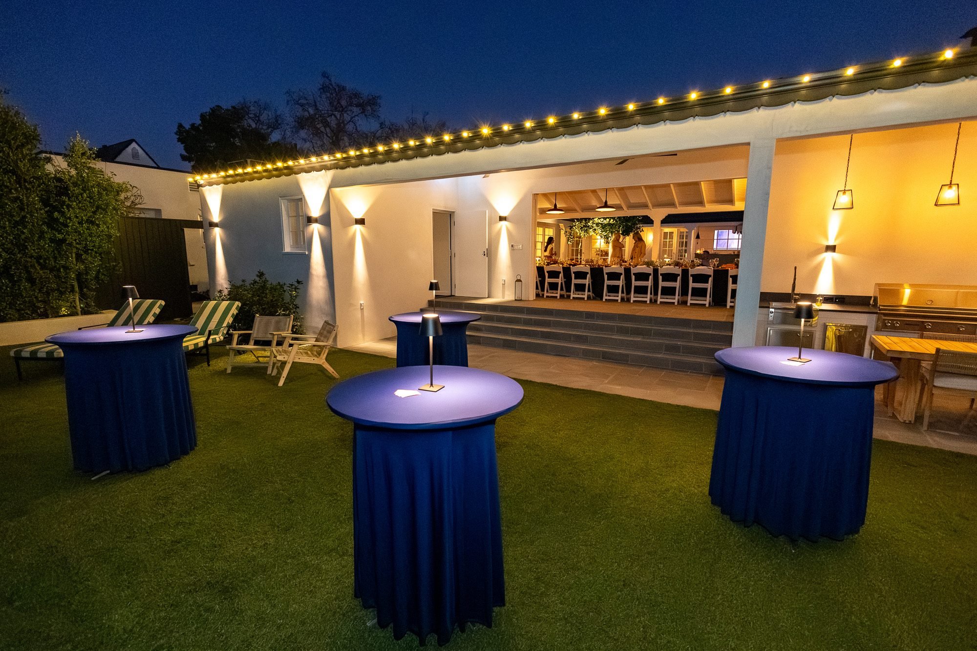 Cocktail tables set up on the lawn for an evening reception