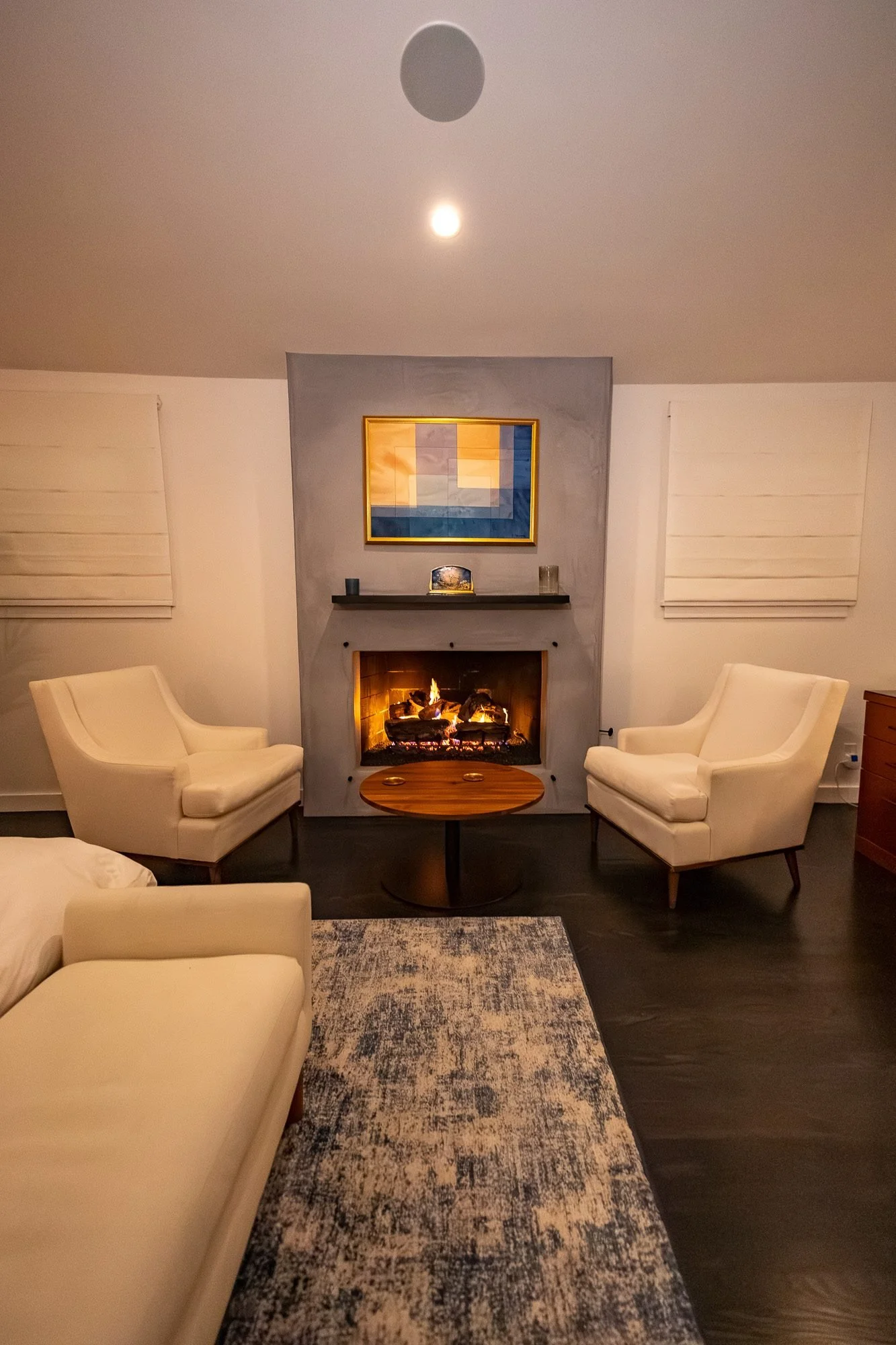Bedroom fireplace flanked by two armchairs