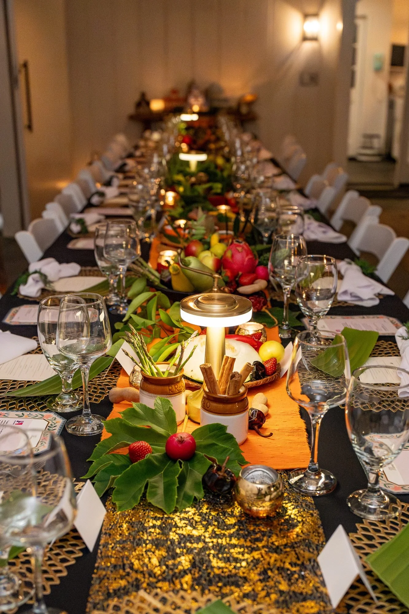 Long table set for a large private dinner with candlelight