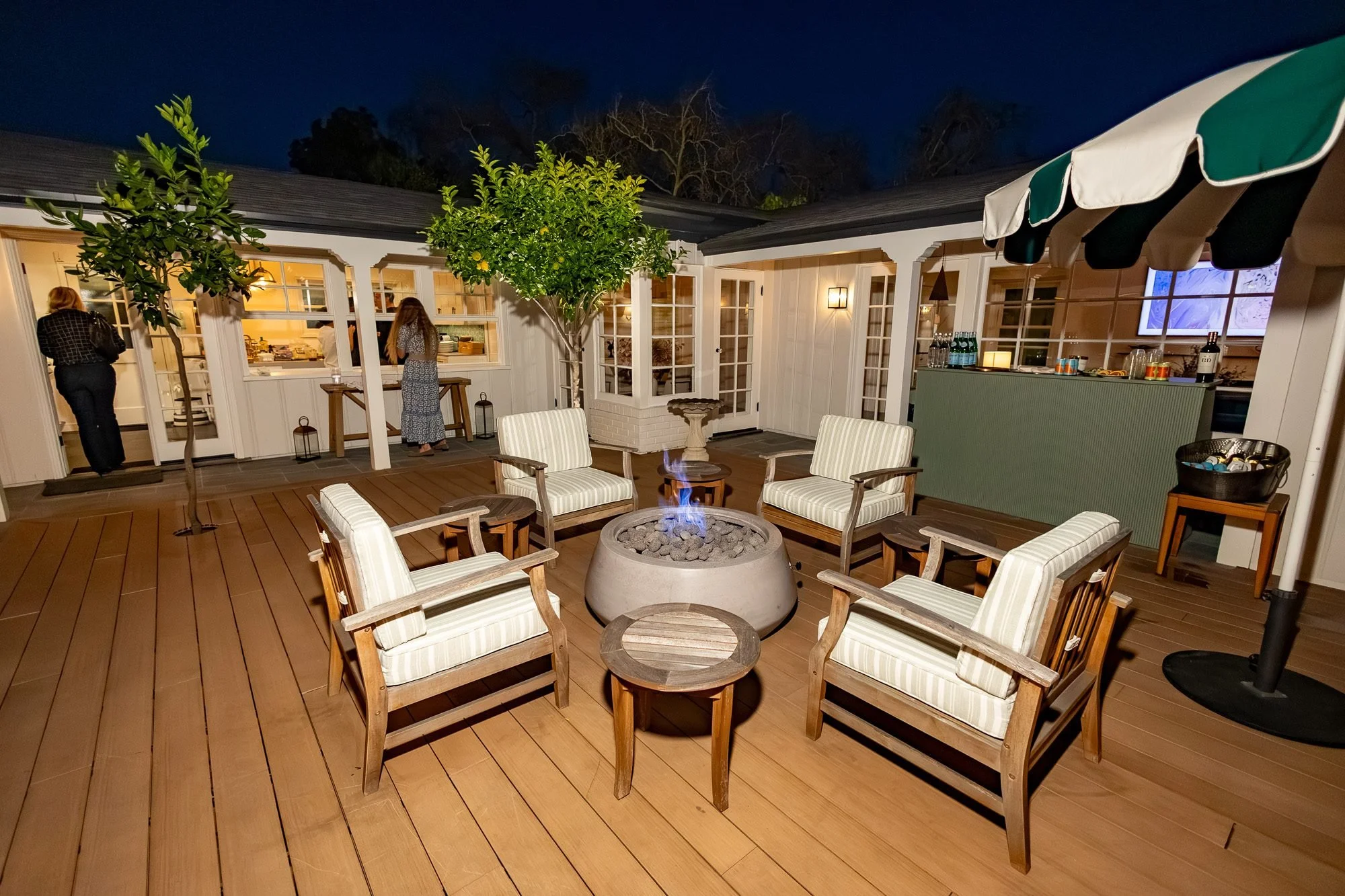 Covered patio lounge with fire pit, bar, and outdoor kitchen