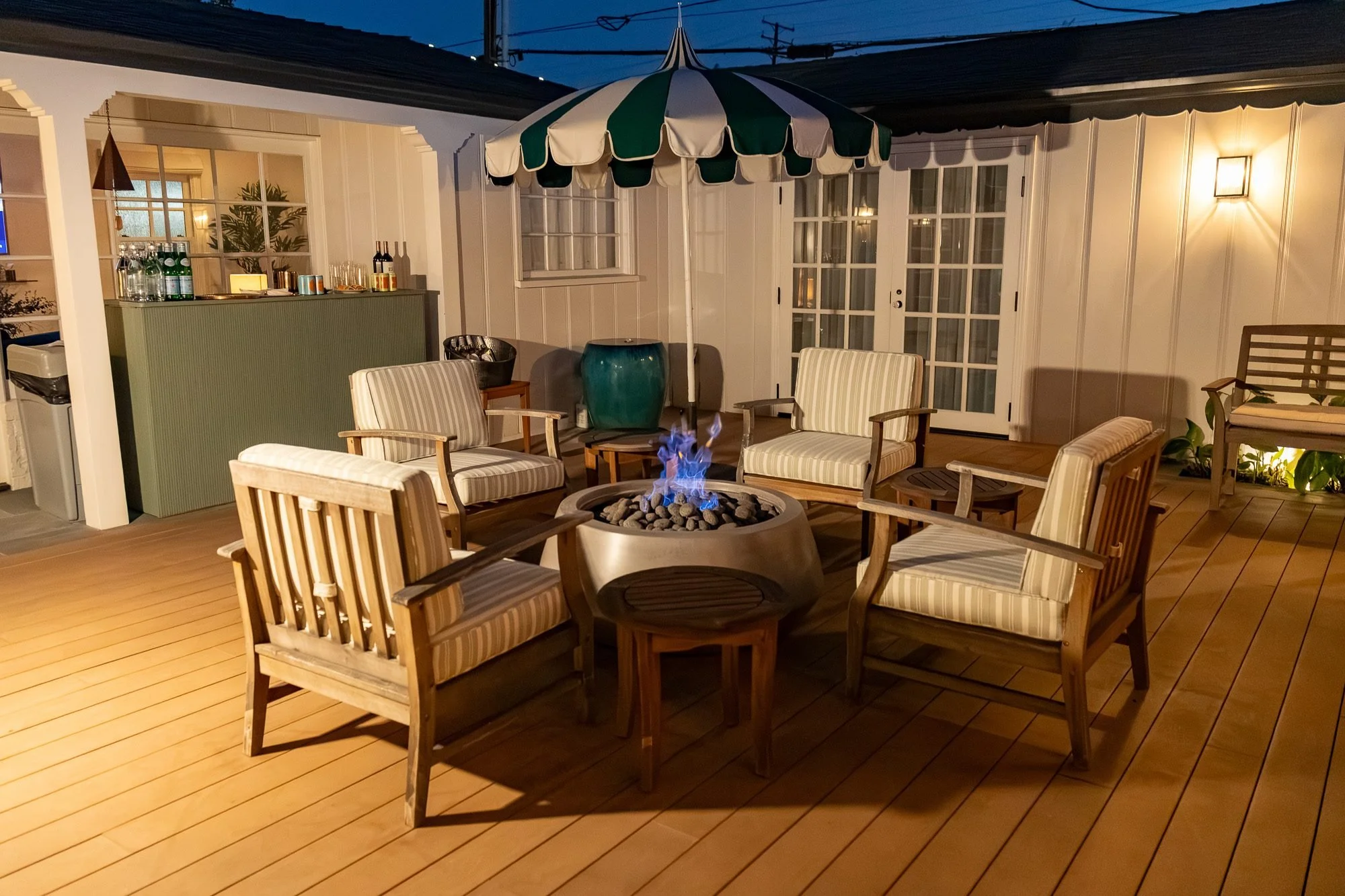 Covered patio lounge seating around a fire pit near the bar