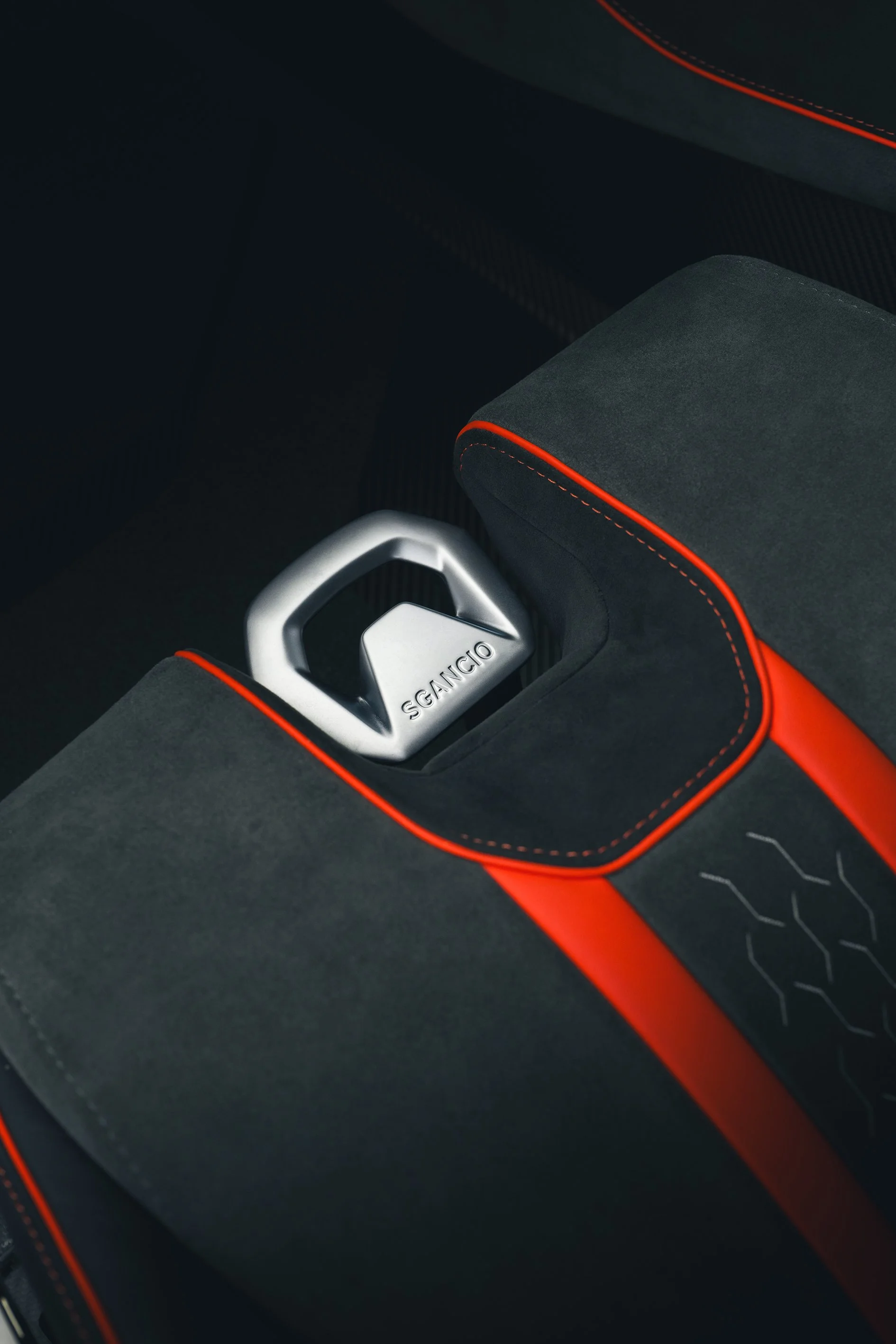 Close-up of a modern gear shift inside a car with black and red interior accents and the word 'SEGIACIO' engraved on it.