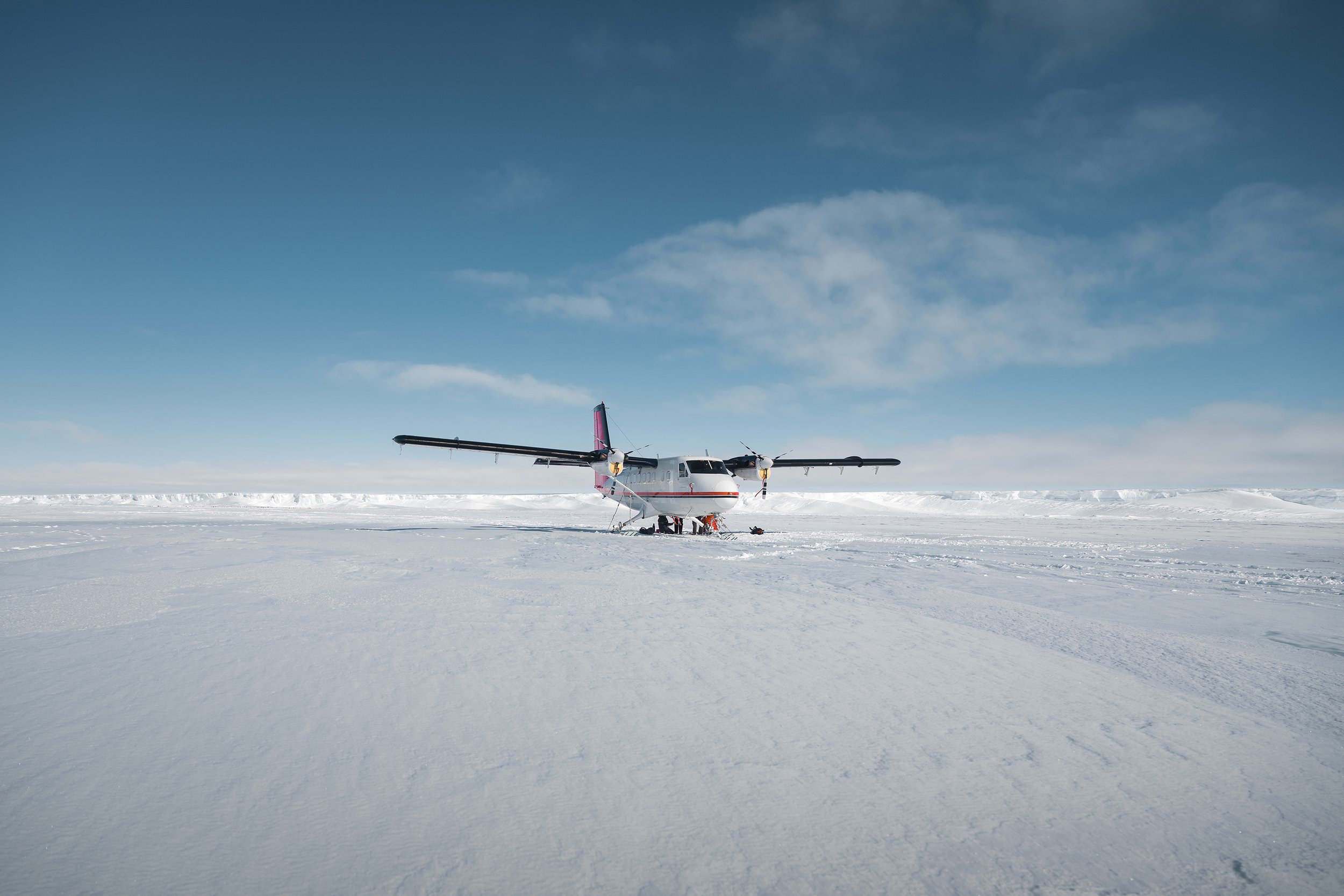 Twin-engine airplane on snow and ice in a polar region.