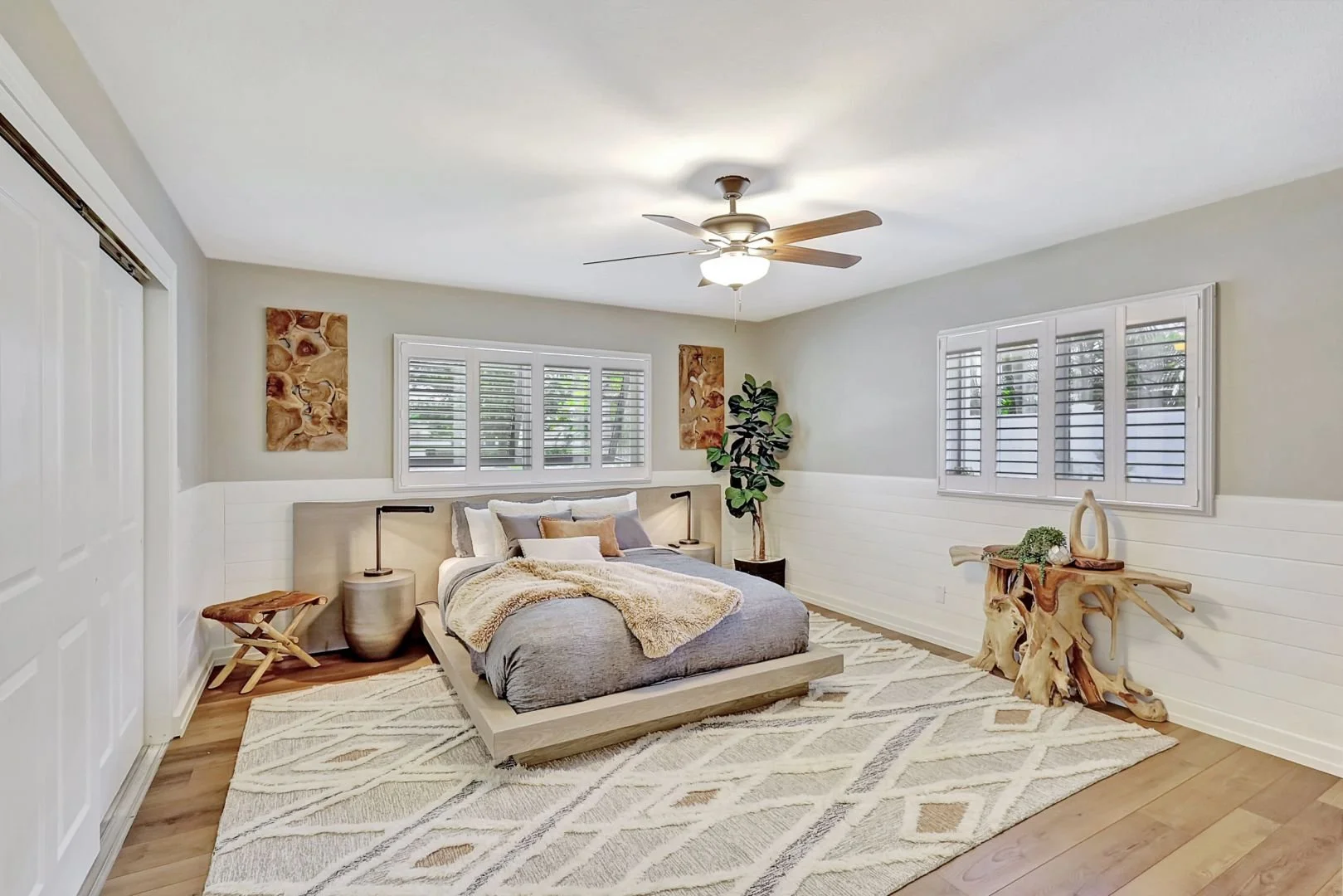 soothing real estate photo of well decorated bedroom in beige and gray tones with large area rug