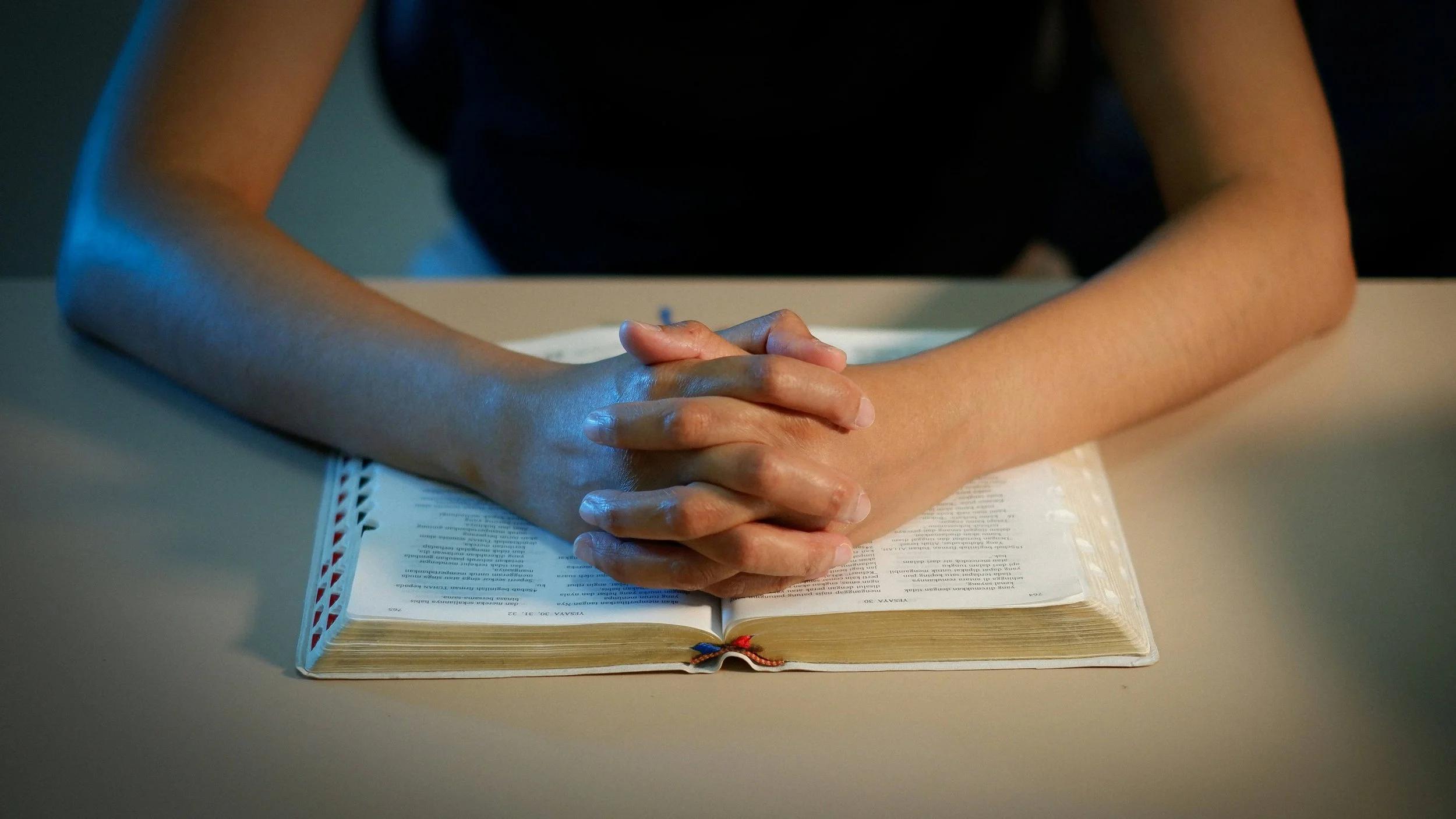 A woman rests her hands over an open Bible. Christian counseling in Columbus, OH, integrates Scripture with clinical therapy to support emotional healing, anxiety recovery, and trauma care for Christian women seeking faith-aligned support.