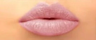 Close-up of a person's lips with light pink lipstick.