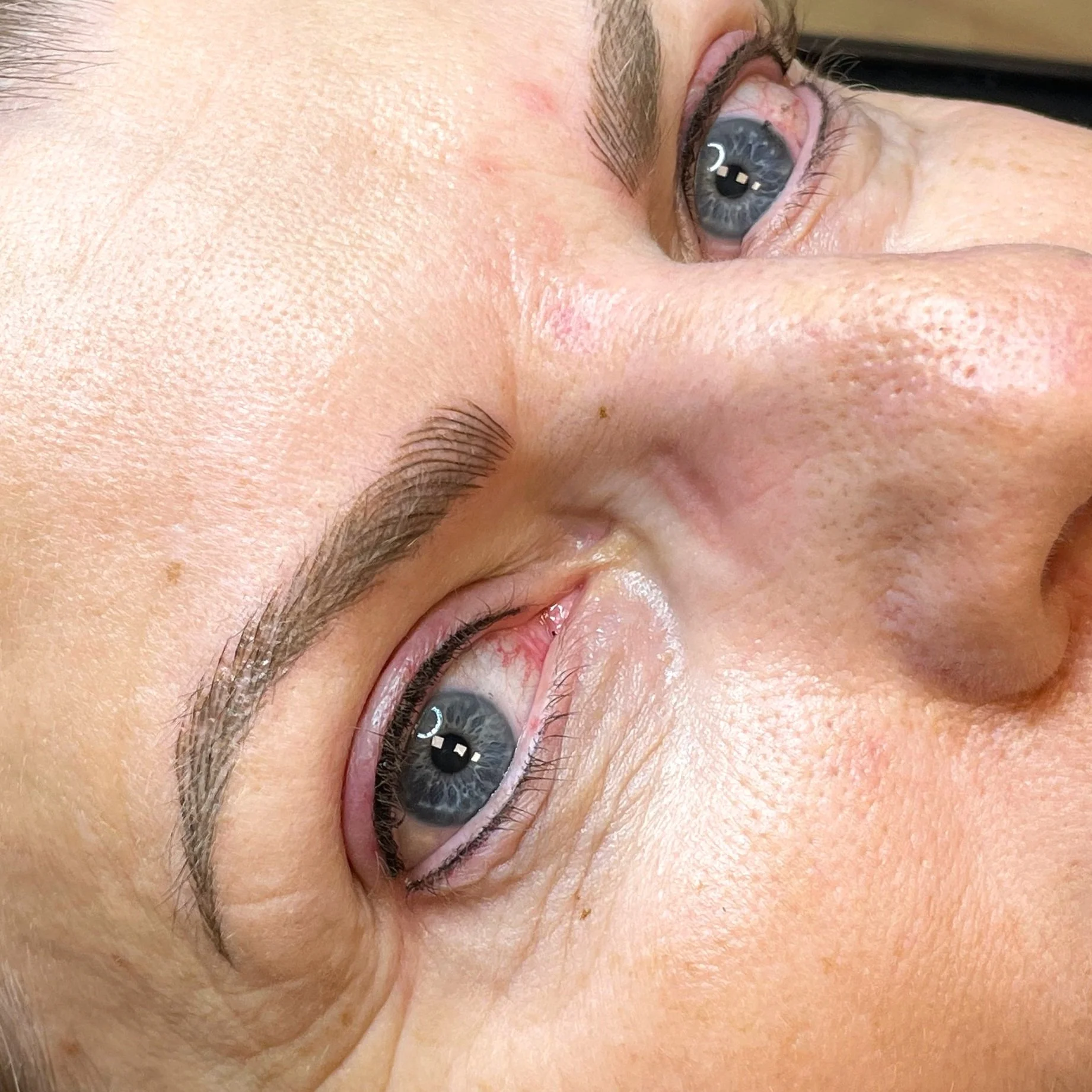 Close-up of a person's face showing a detailed view of the eye, eyebrow, and skin texture.