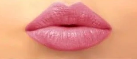 Close-up of pink lips against a plain background.