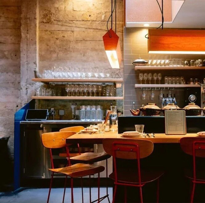 State Bird's dining room showing the bar seating, lighting, glassware, and menus