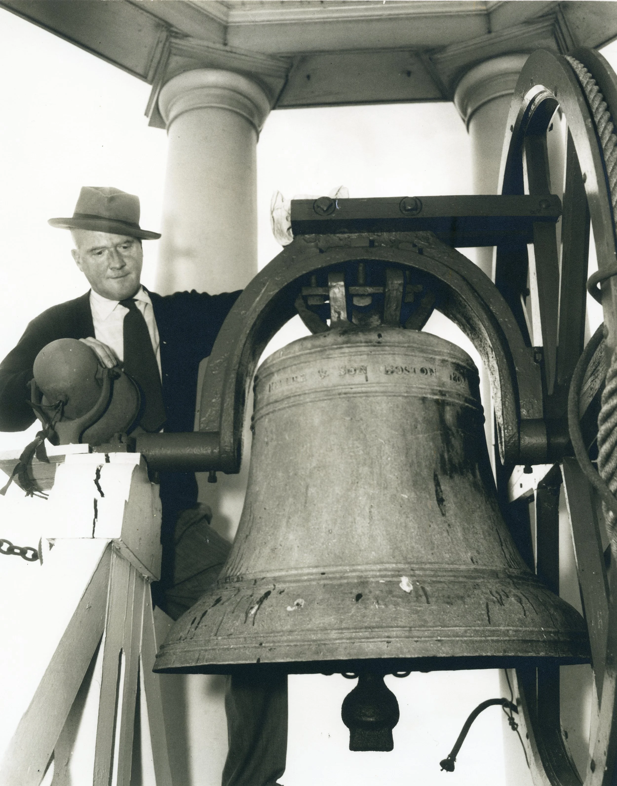 Theodore Burns, City Messenger, standing by the Paul Revere Bell atop Bath City Hall. The Bath Daily Times of June 1957 reported that Burns had painted the bell tower, sprucing it up for summer visitors. BHS2010.11.6