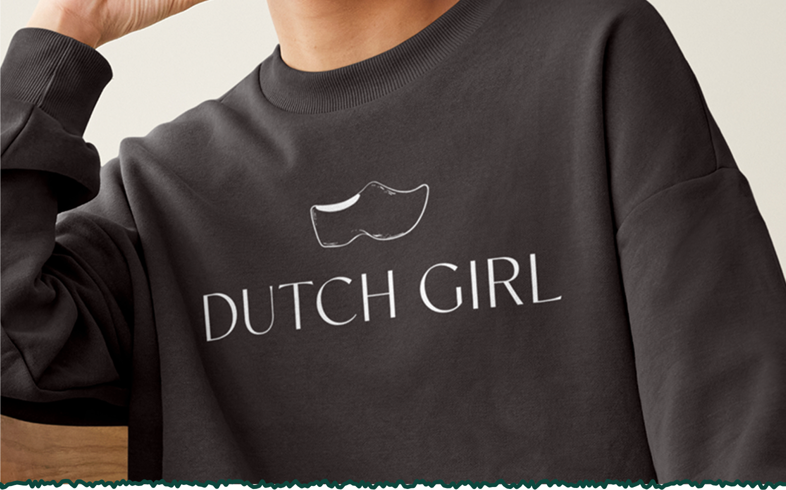 Person wearing a black sweatshirt with a white outline of a Dutch clog and the text 'DUTCH GIRL' written below it.