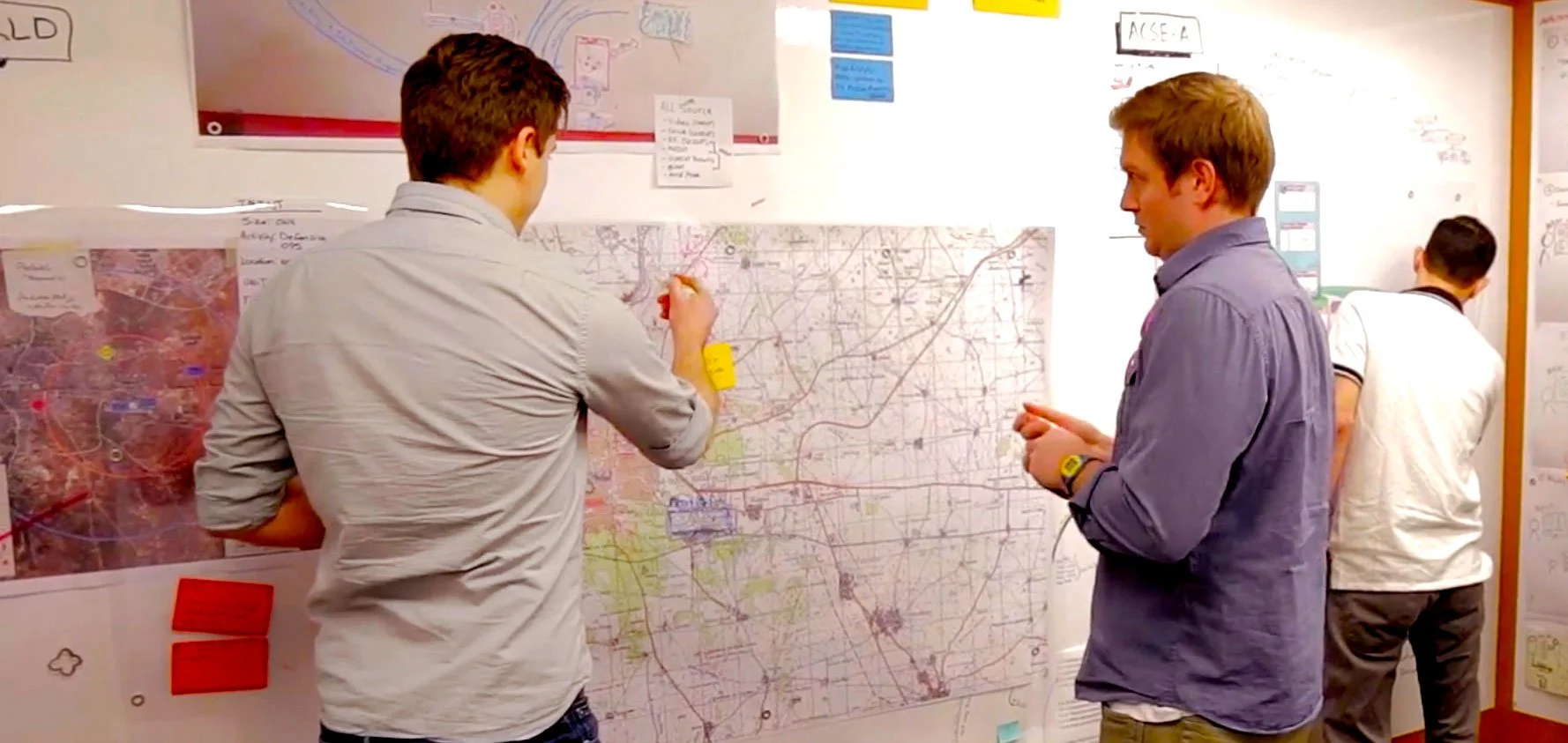 Resilient Cognitive Solutions cognitive systems engineers working on maps and charts on a project wall.