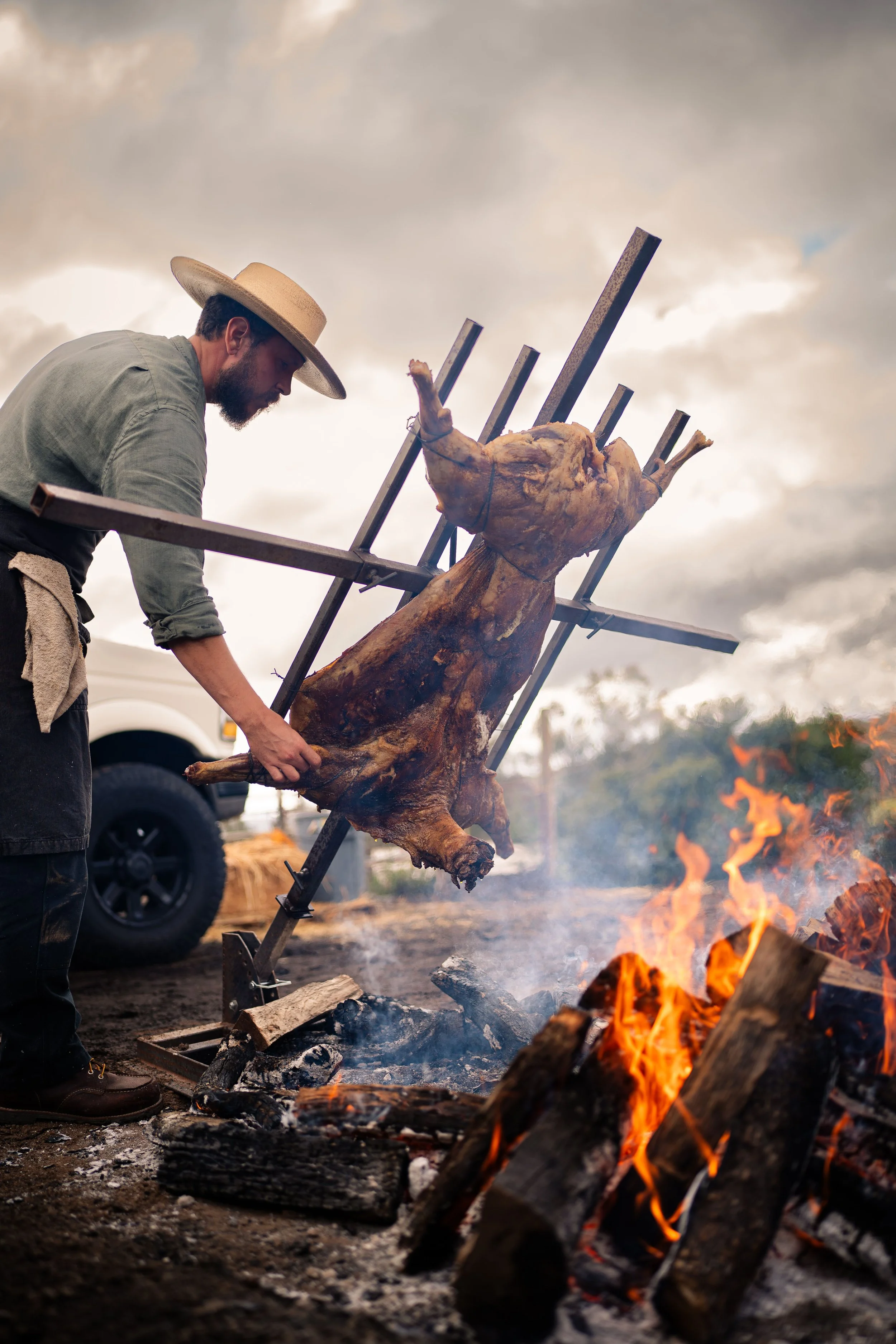 Chef Doug preparing whole-animal barbecue over a live fire, honoring Hearth & Harvest’s Appalachian and old-world culinary heritage.