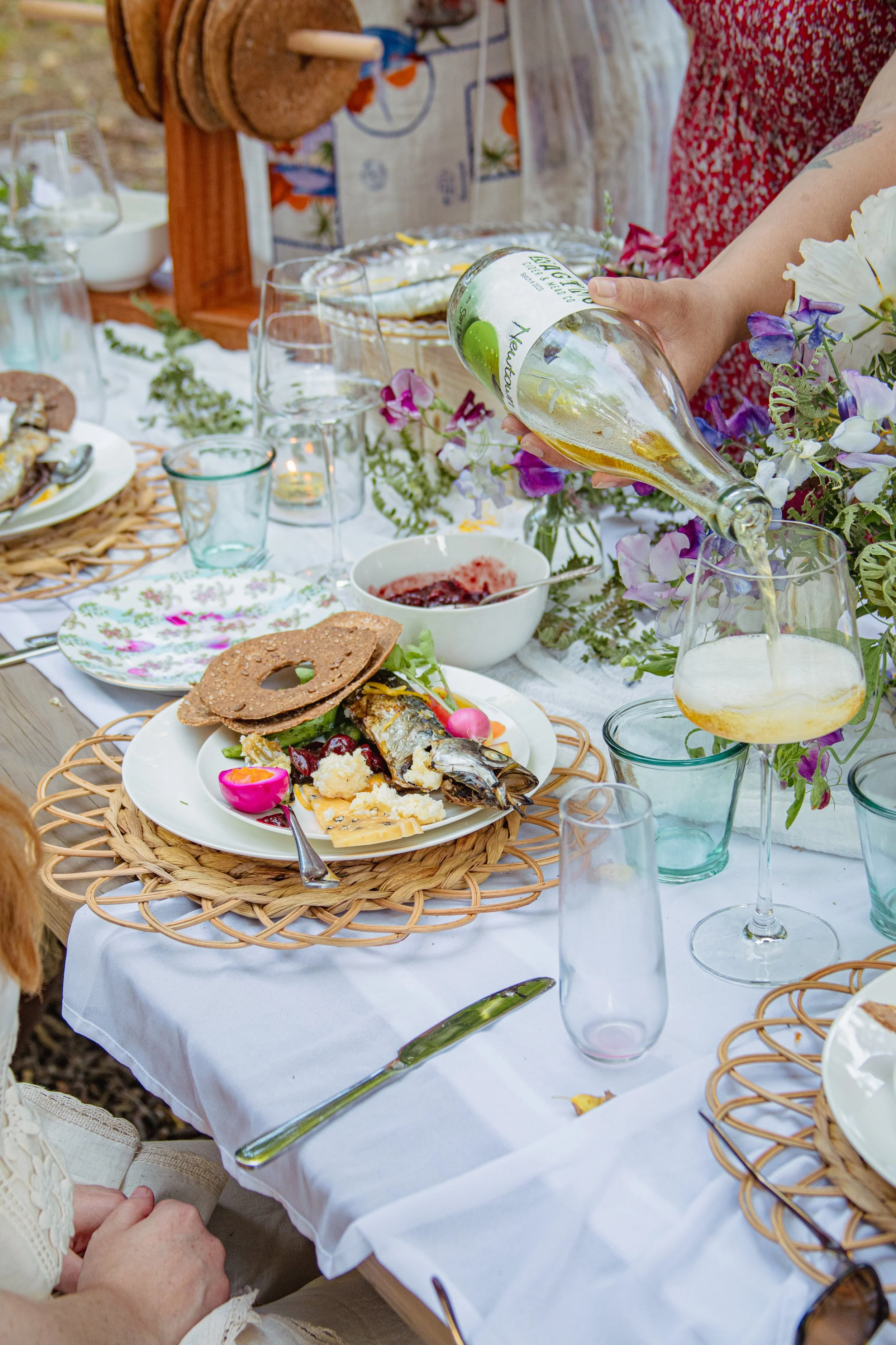 Rustic garden wedding tablescape with seasonal flowers, handcrafted breads, and a plated farm-to-table meal, catered by Hearth & Harvest for Southern California weddings.