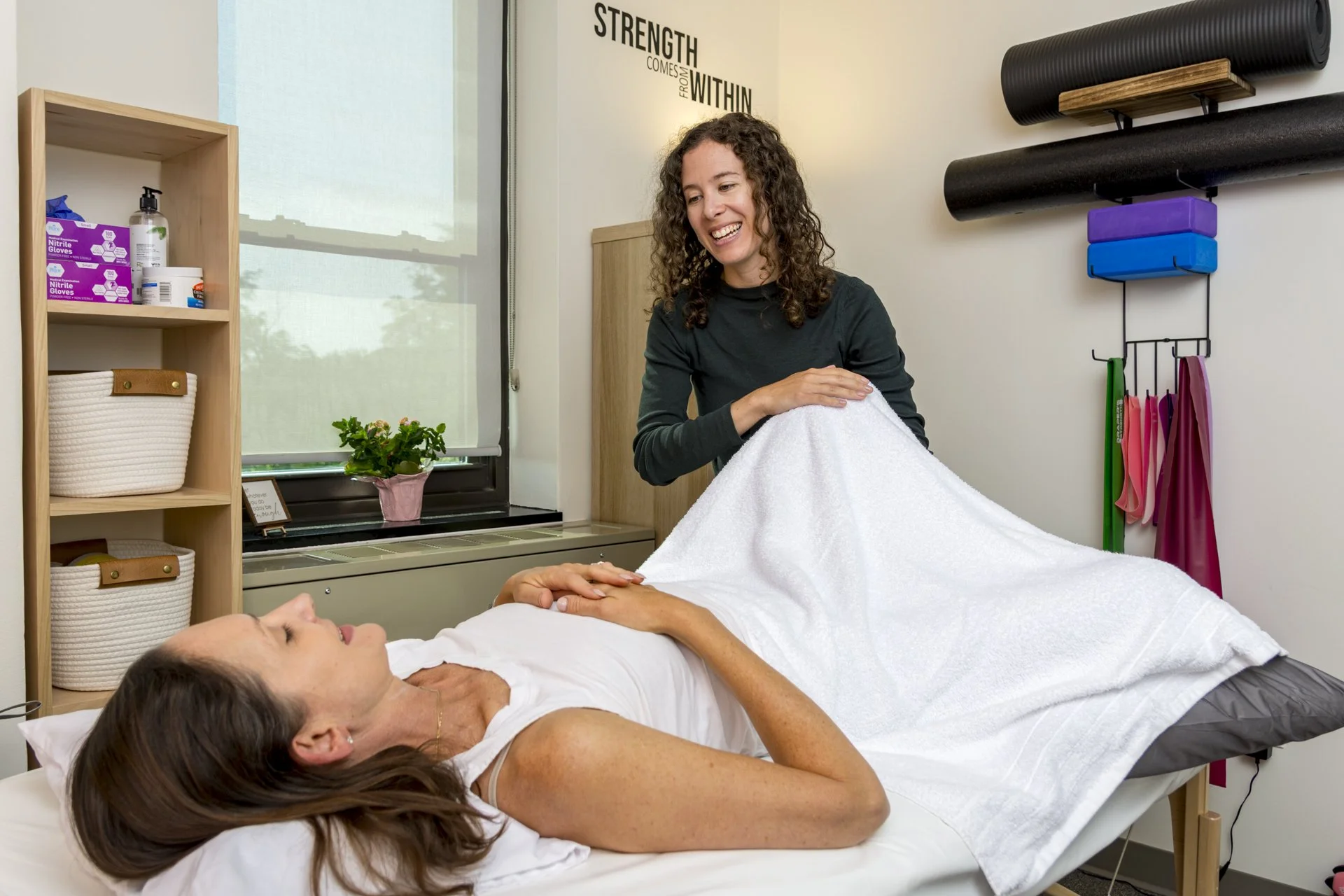 physical therapist teaching exercise with patient on hands and knees