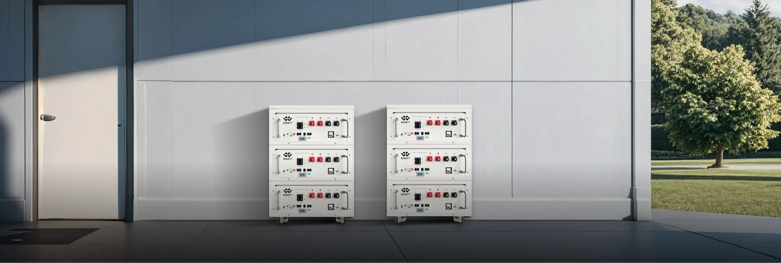 Vier witte elektrische laadpalen met rode en zwarte aansluitingen staan naast een modern gebouw. Buiten is er gras en een boom te zien.