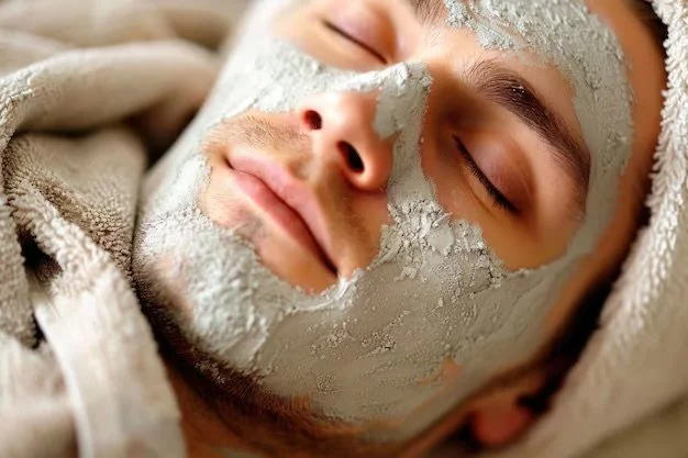 Close-up of a man with a facial mask relaxing with eyes closed.