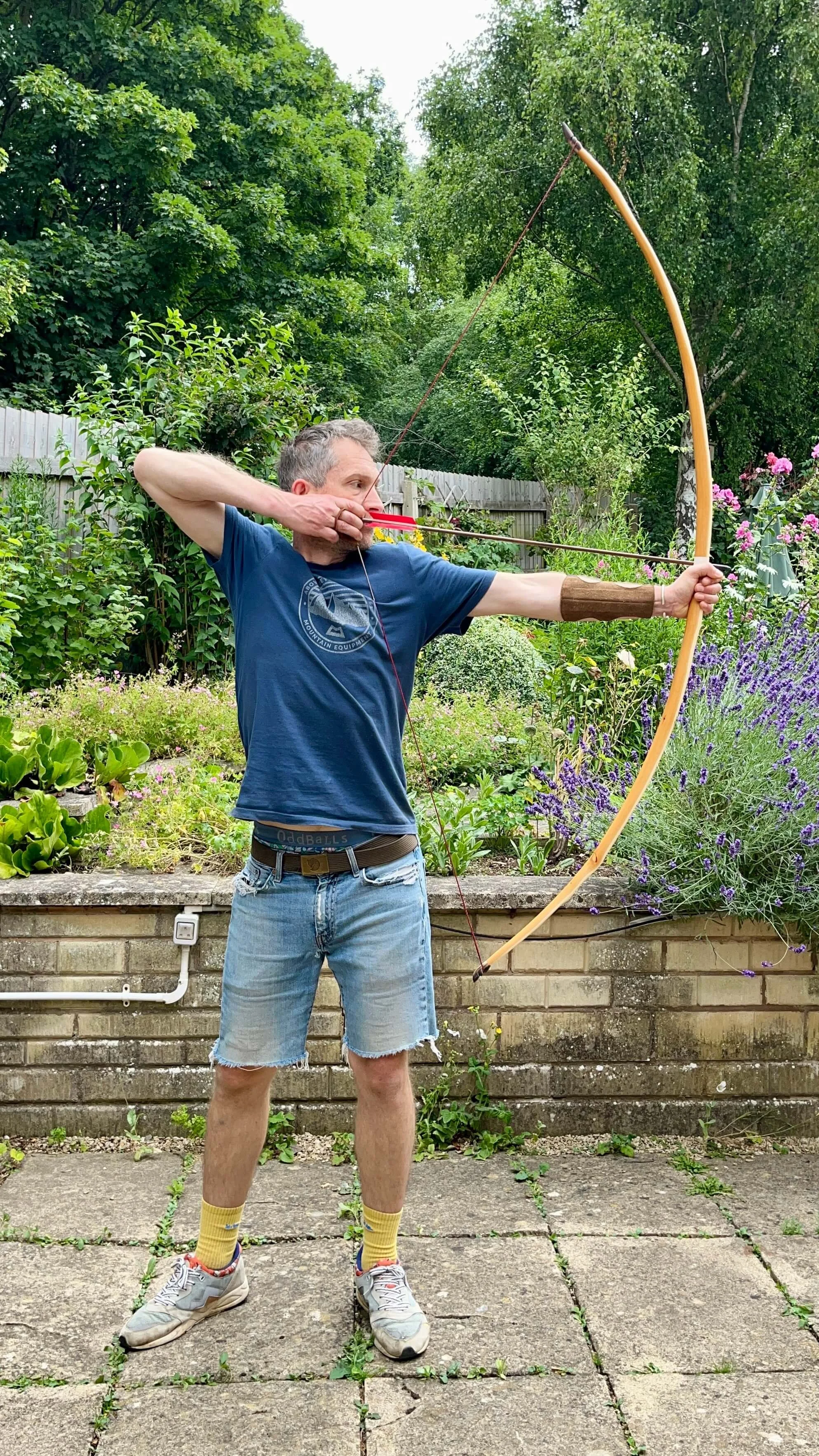 An pacific yew English longbow being held at full draw to show its tiller.