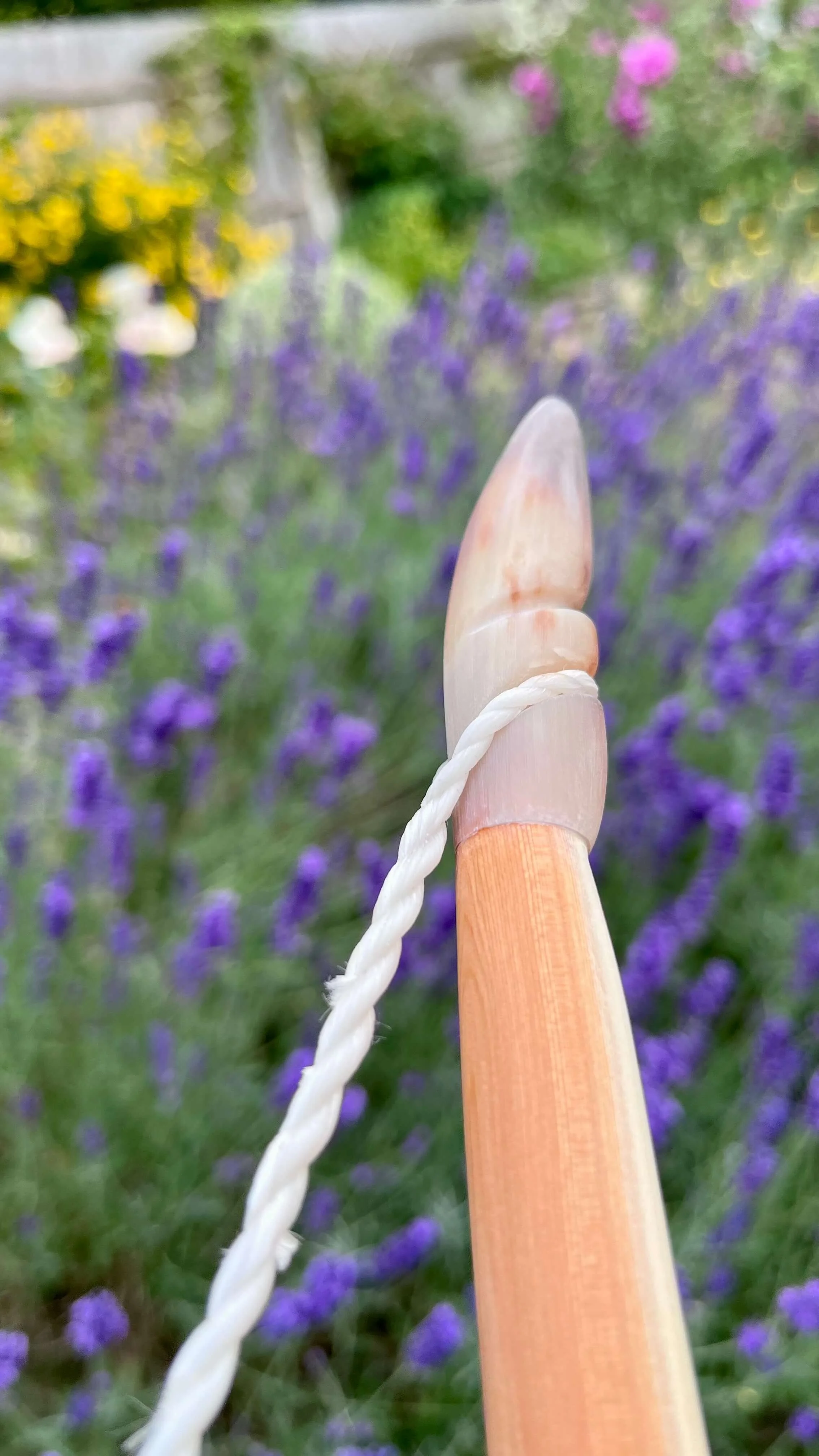 A fitted, streaky buffalo horn nock on a strung bow in profile.