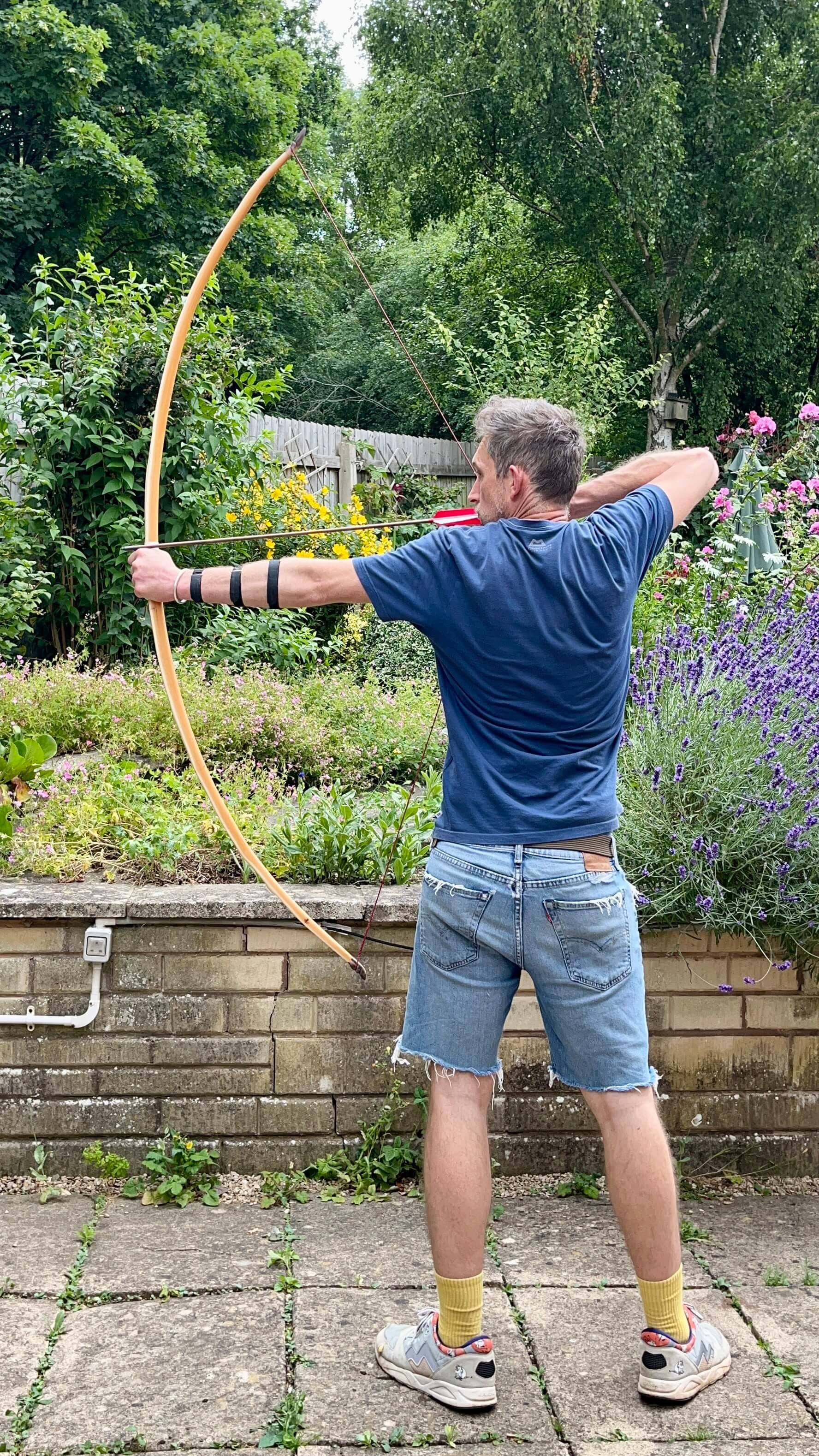 An English yew longbow at full draw showing off its arc and tiller.