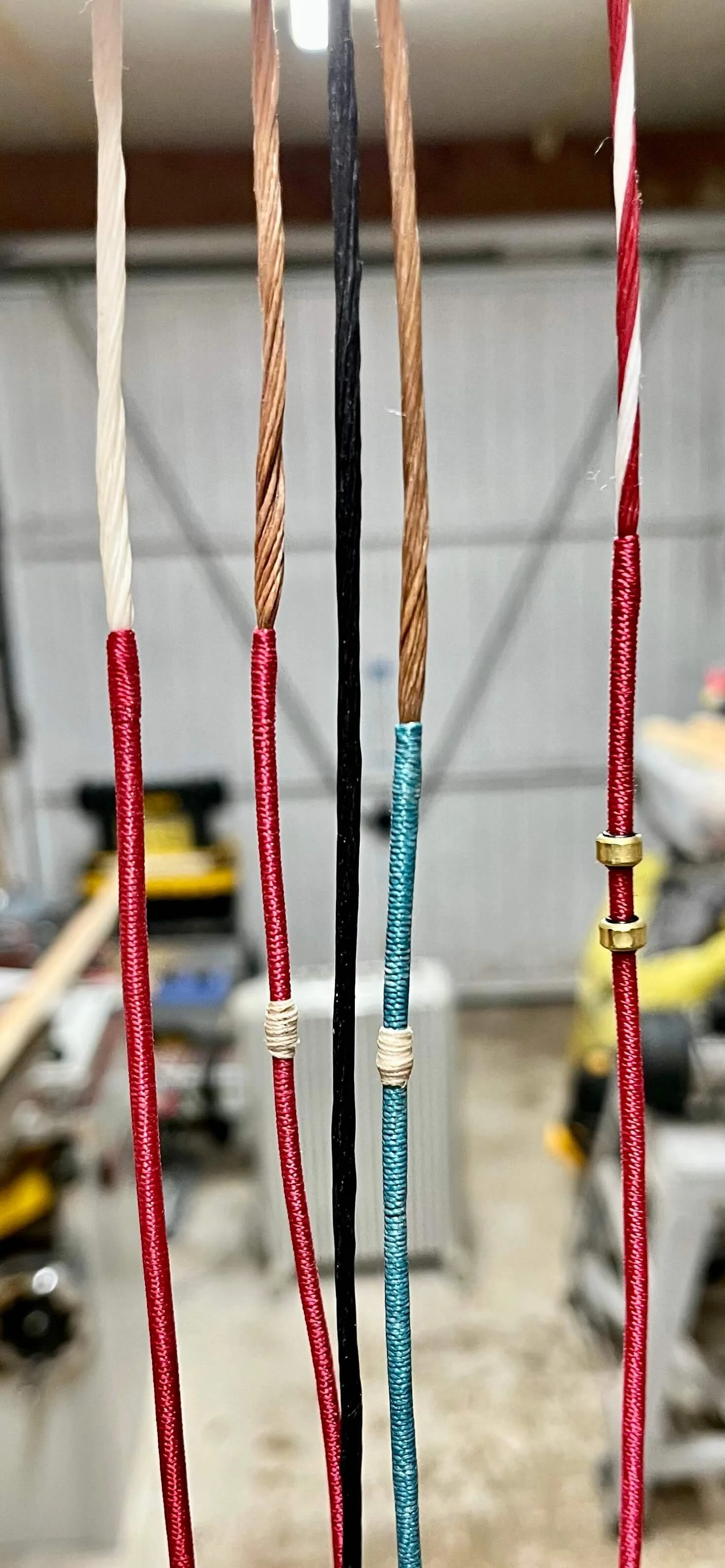 A close-up of several bow strings with servings.  In various colours.