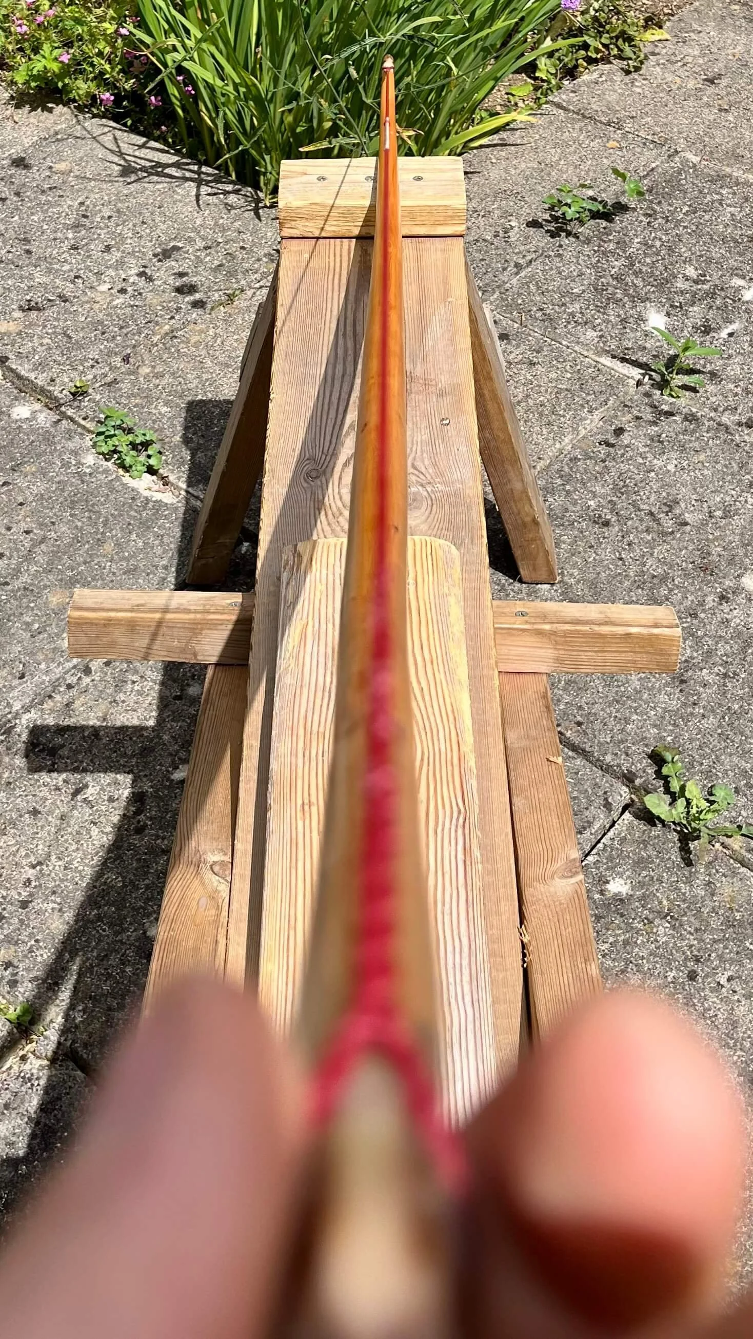A bow resting on a shave hose showing that the string bisects the handle section precisely.
