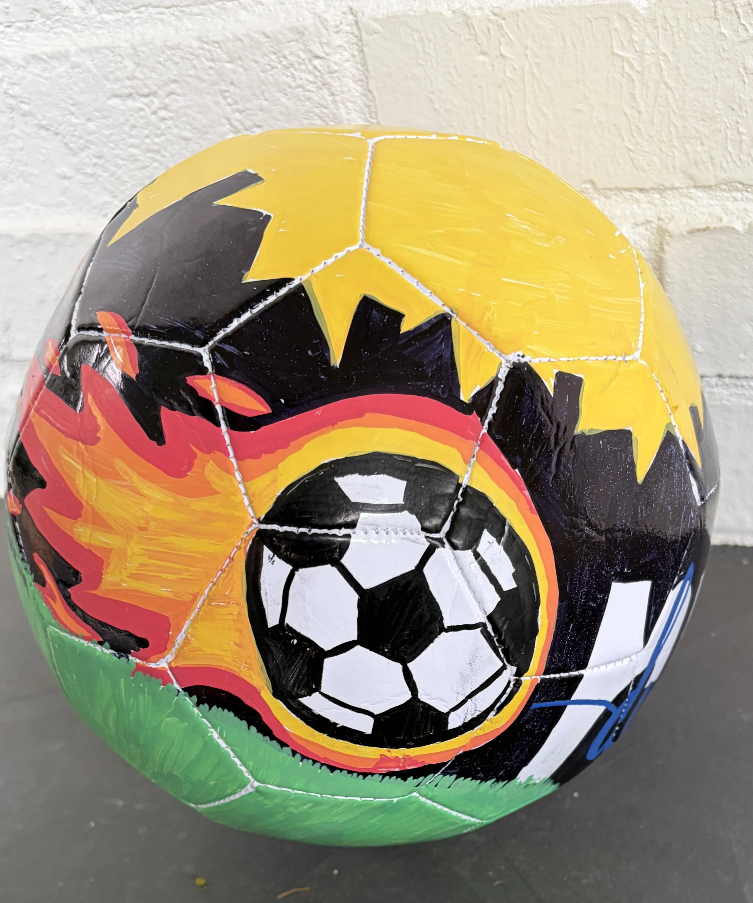 City of Champions (back) by Linley McGukin: My artwork represents how sports bring a city together. The skyline, field, and soccer elements symbolize teamwork, dedication, and the dreams that inspire athletes to become champions both on and off the f