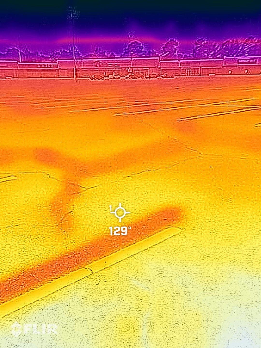 This thermal image shows a temperature reading of 129 degrees on the parking lot pavement at Southside Plaza on a summer day. The purple and pink colors along the tree line indicate cooler temperatures in the shade.