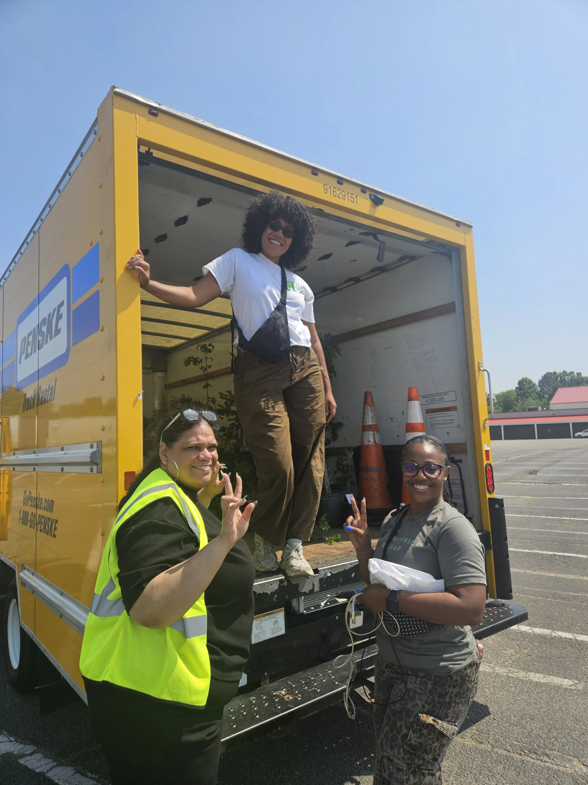 Amy, Syd, and Brandi from Southside ReLeaf posing for a photo while loading the box truck at the event's end.