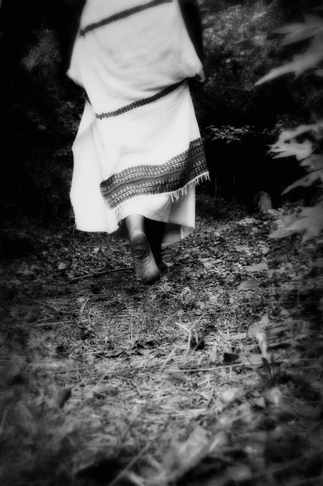 Barefoot Brown woman walking through the forest