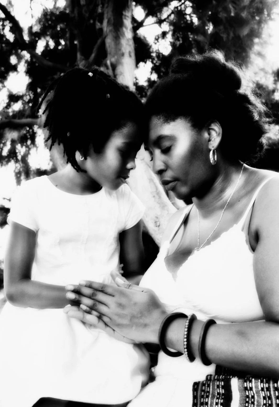 Brown-skinned mother and daughter making the family tree promise
